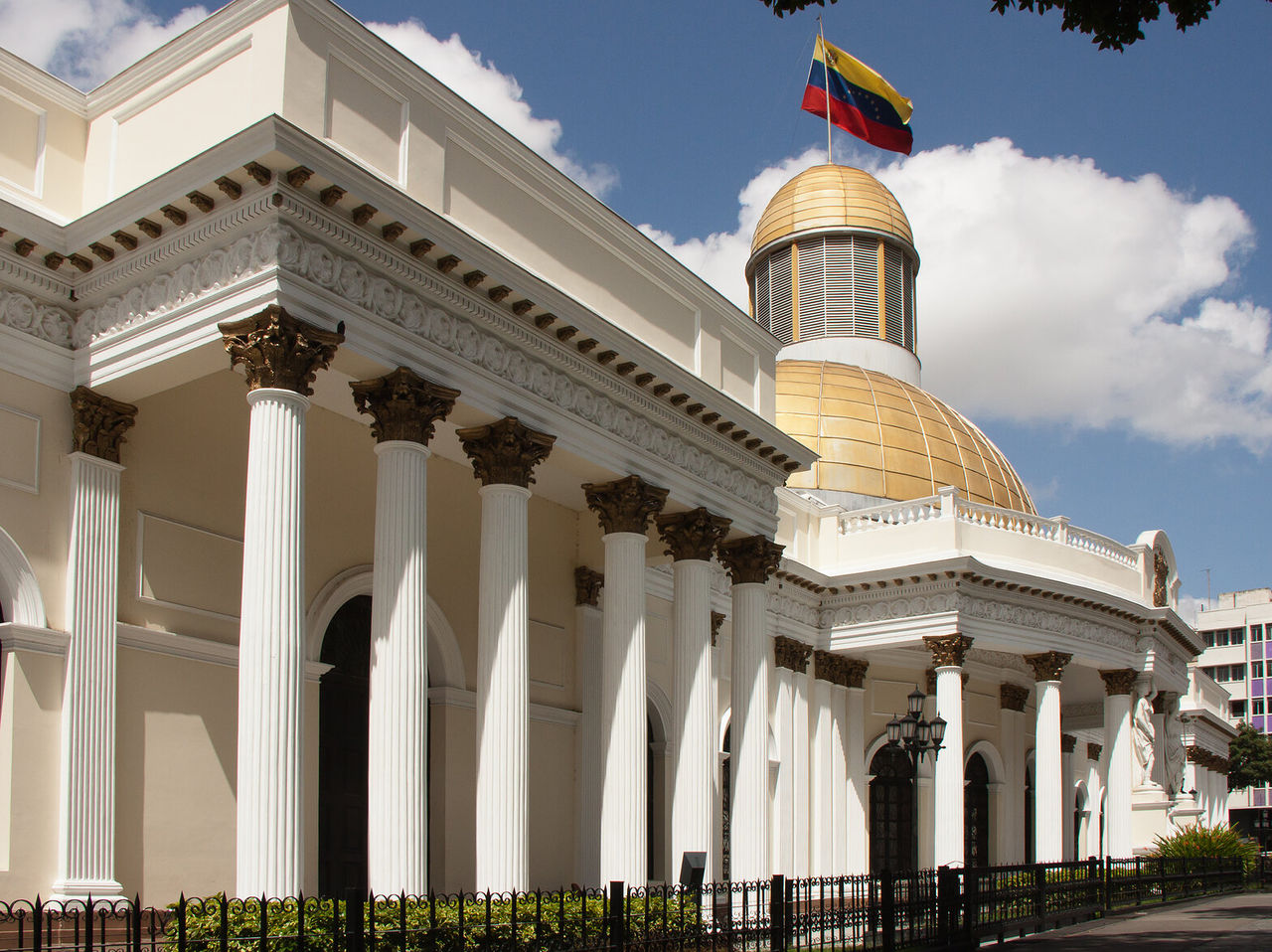 Imponente fachada del Palacio Federal Legislativo en Caracas, con columnas blancas y una cúpula dorada