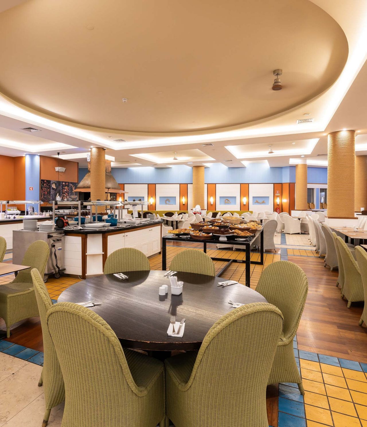 El restaurante Marés, del Resort de 5 estrellas en Porto Santo, tiene un espacio amplio con paredes amarillas y sillas verdes