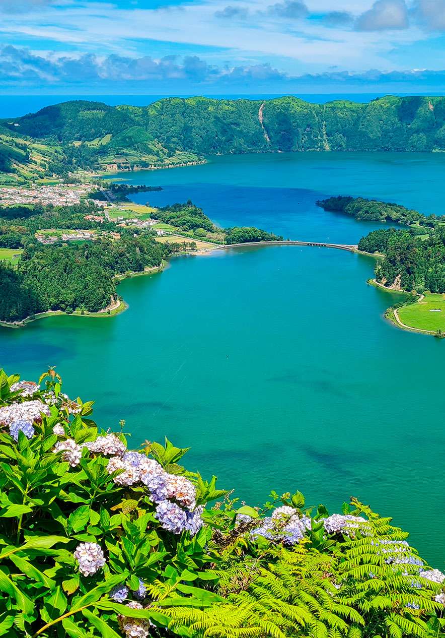 Vista de cima da Lago das Sete Cidades, com as duas lagoas azul e verde, no meio de uma densa vegetação verde