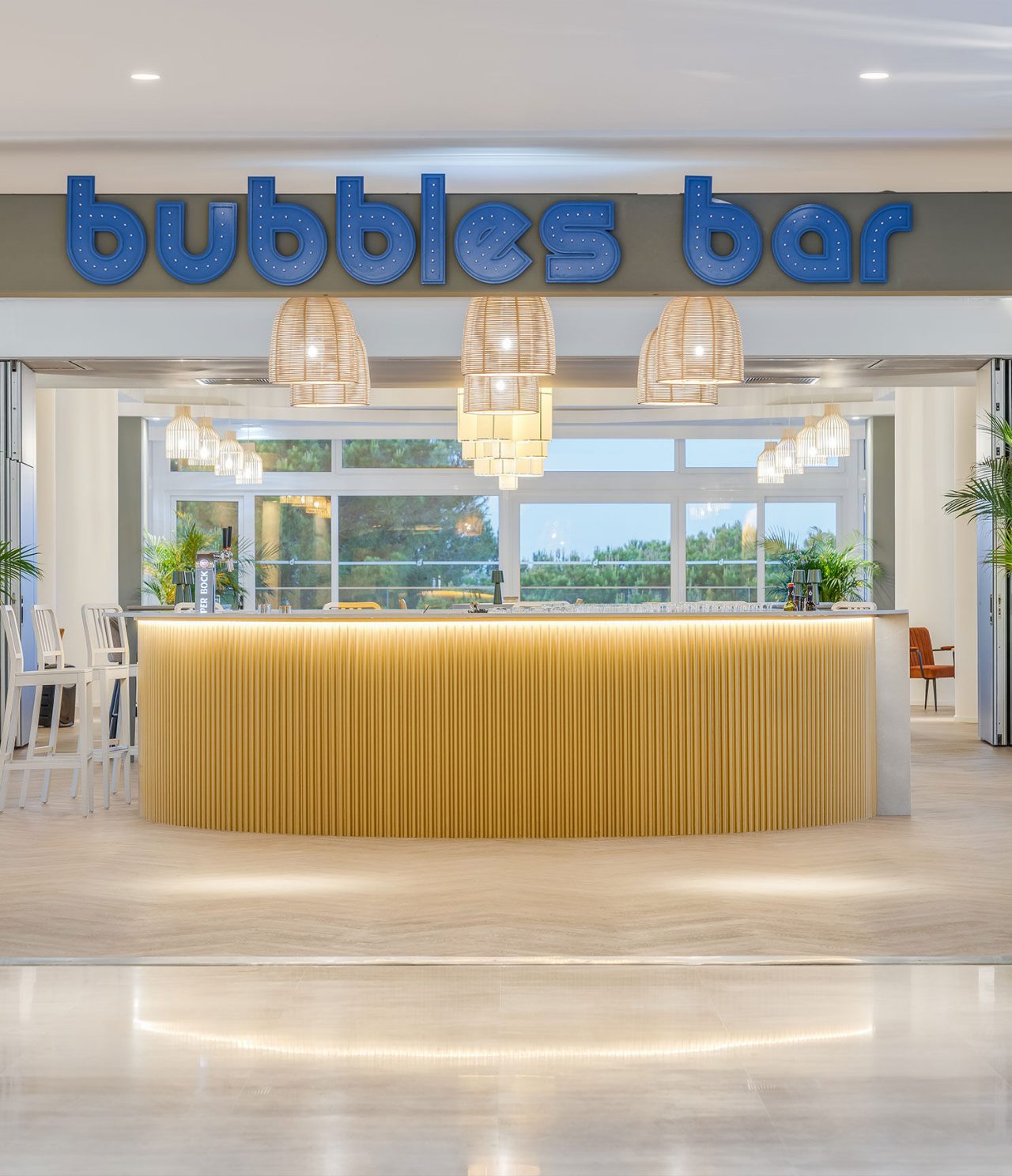 O bar Bubbles, do Hotel Tudo Incluído no Algarve, tem um balcão redondo com madeira clara e o logotípo