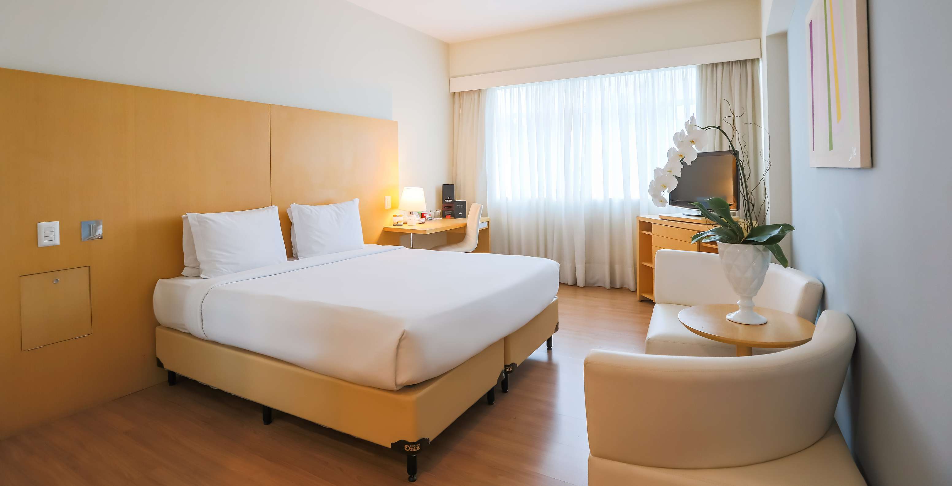 Der Queen Standard im Pestana Curitiba hat ein Zimmer mit Doppelbett, Sofas, einem Schreibtisch und einem TV-Möbel
