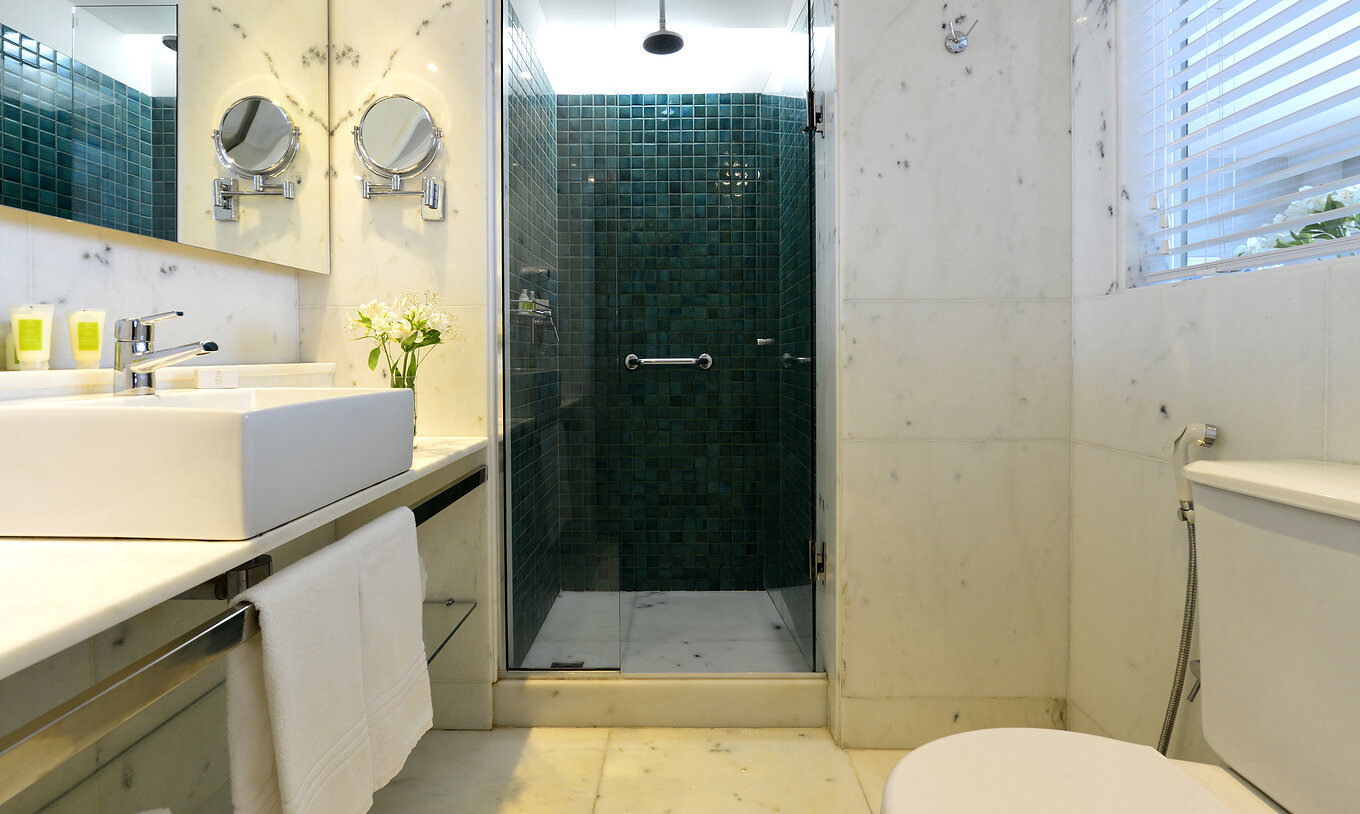 Das Zweibettzimmer mit Seitlichem Meerblick hat ein Bad mit Dusche, Toilette, Waschbecken und Spiegel 