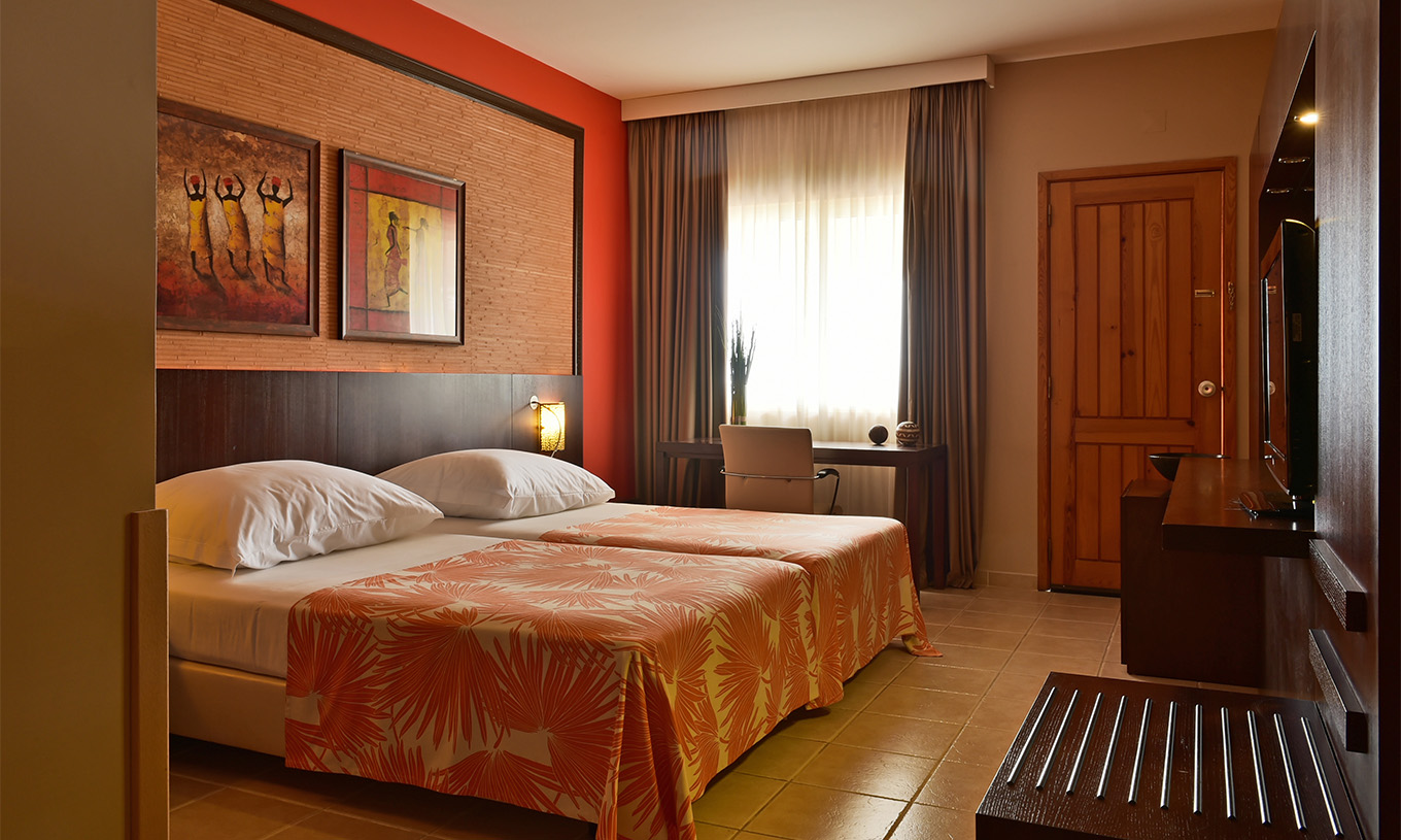 Premium Zimmer Pestana Tropico hat zwei Einzelbetten, Fernseher und Schreibtisch mit Stuhl