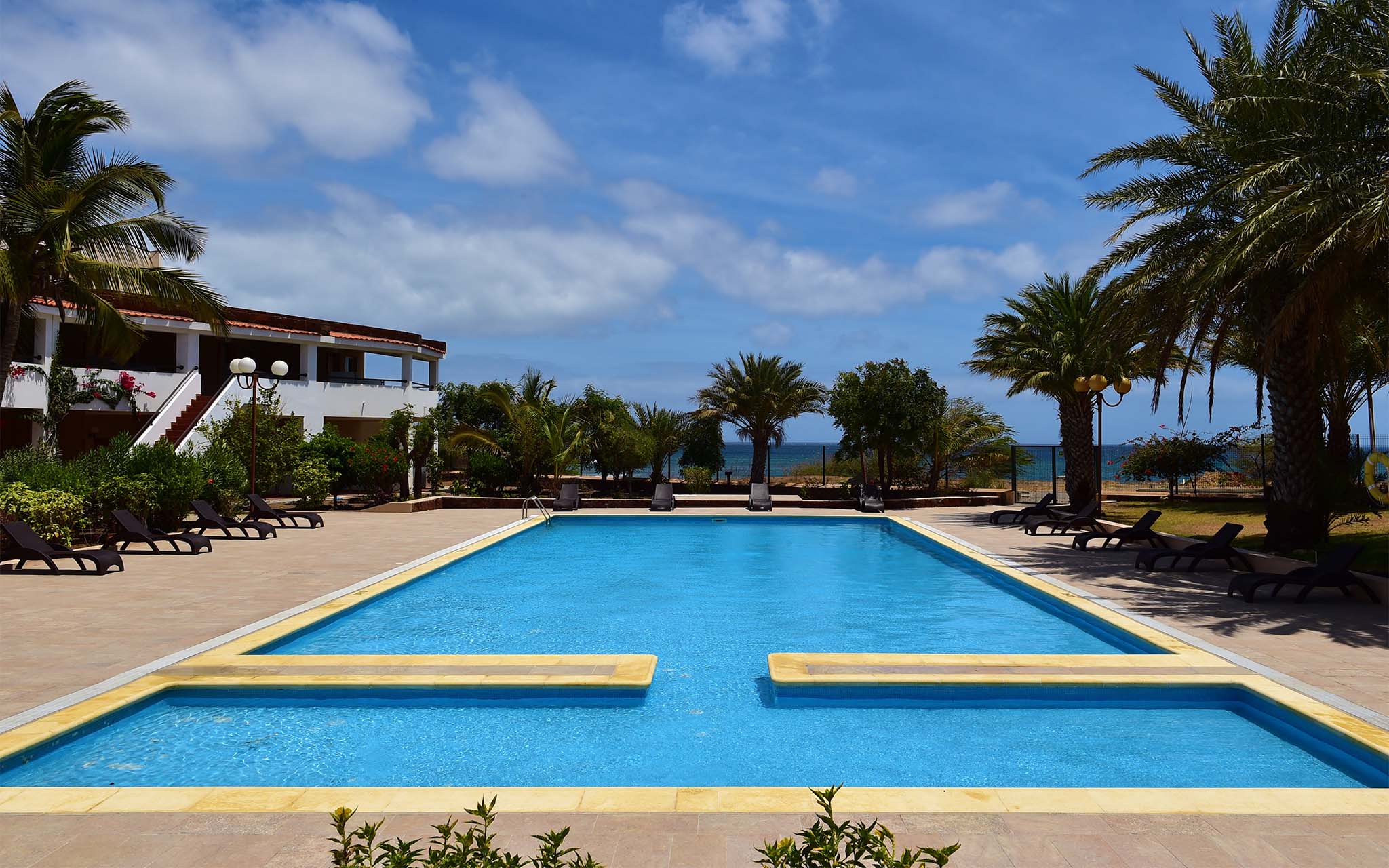 Außenpool des Pestana Tropico mit Palmen und Liegen und Meerblick