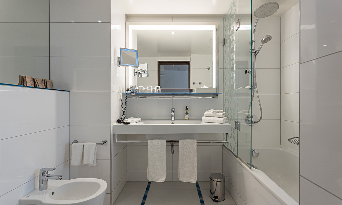 Das Deluxe im Pestana Berlin Tiergarten hat ein Bad mit Badewanne und Dusche und ein Waschbecken