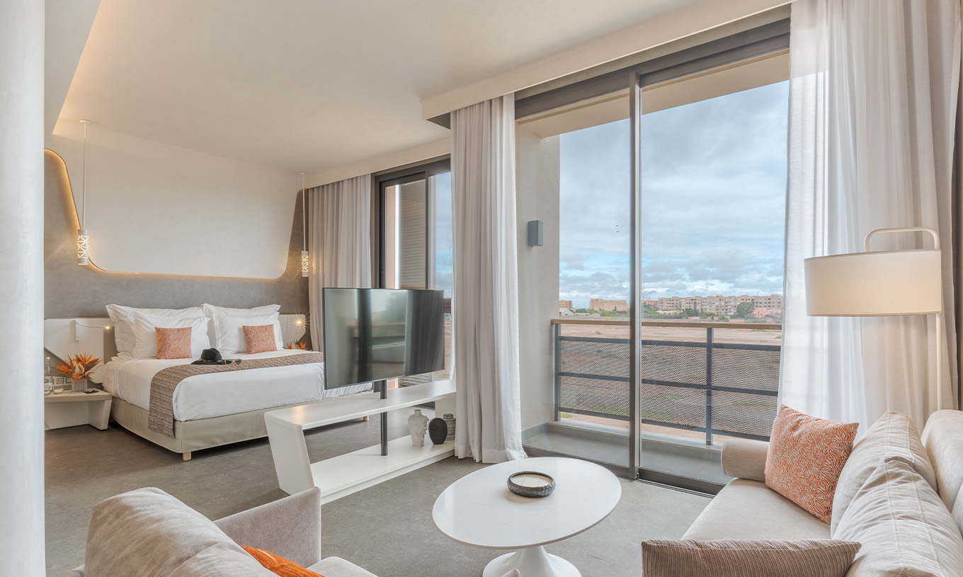 Die CR7 Junior Suite im Pestana CR7 Marrakeck hat einen Balkon und einen Wohnbereich mit Sofas und Fernseher im Zimmer