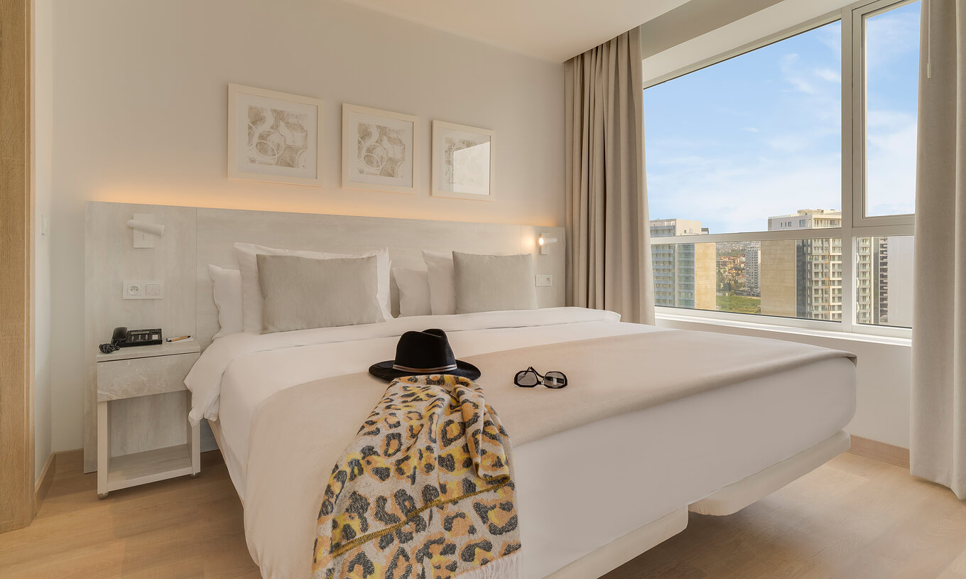 Die Premium-Suite im Pestana Tanger City Center hat ein Doppelbett mit Stein-Kopfteil und ein Fenster mit Aussicht