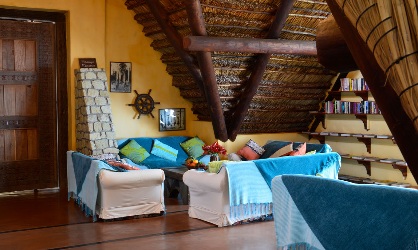 Die Bungalow Suite T2 im Pestana Bazaruto Lodge hat ein geräumiges Zimmer mit Sofas mit blauen Decken und bunten Kissen