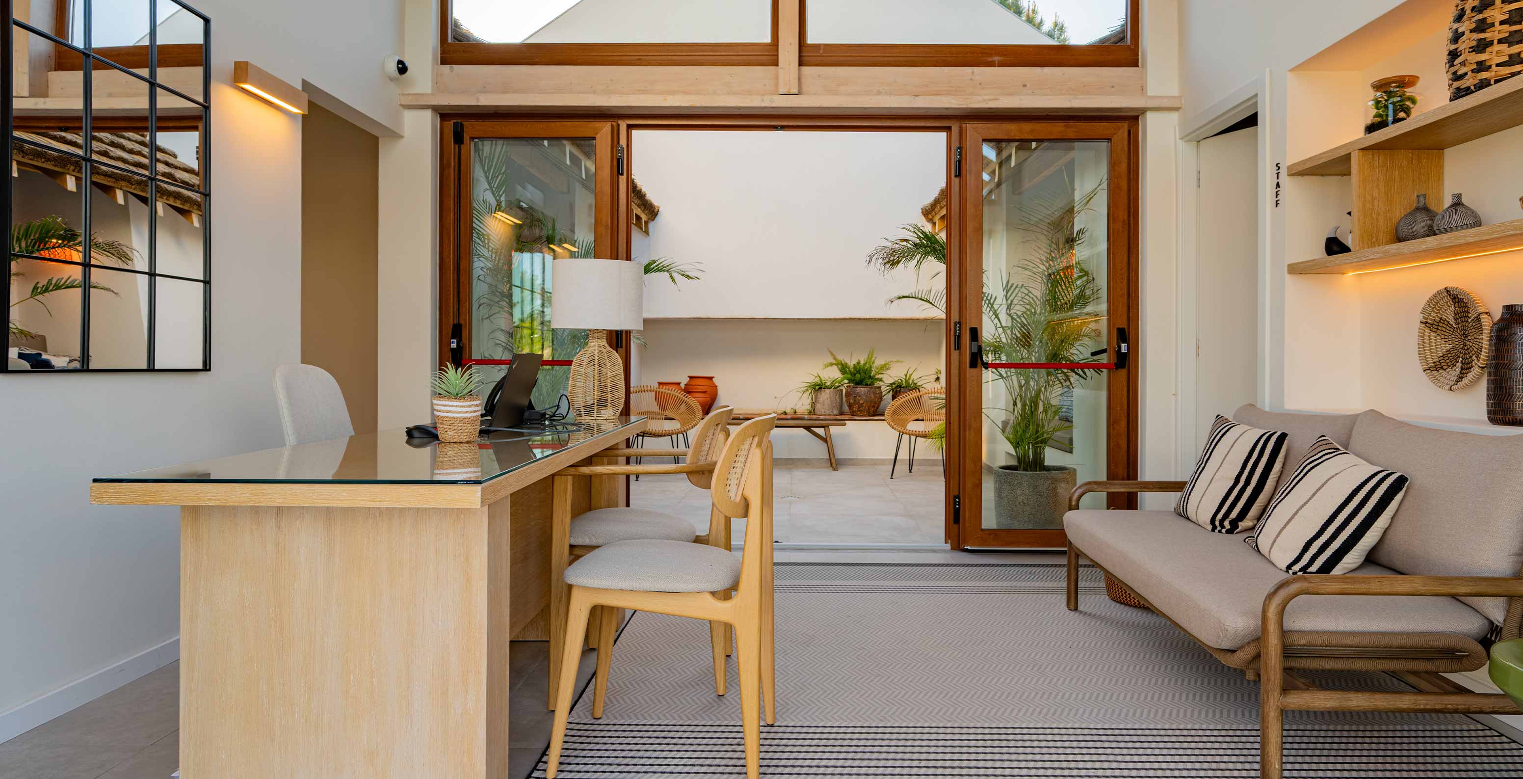 Moderne und gemütliche Rezeption mit Sofa und doppelt verglasten Türen im Pestana Comporta Village Residences