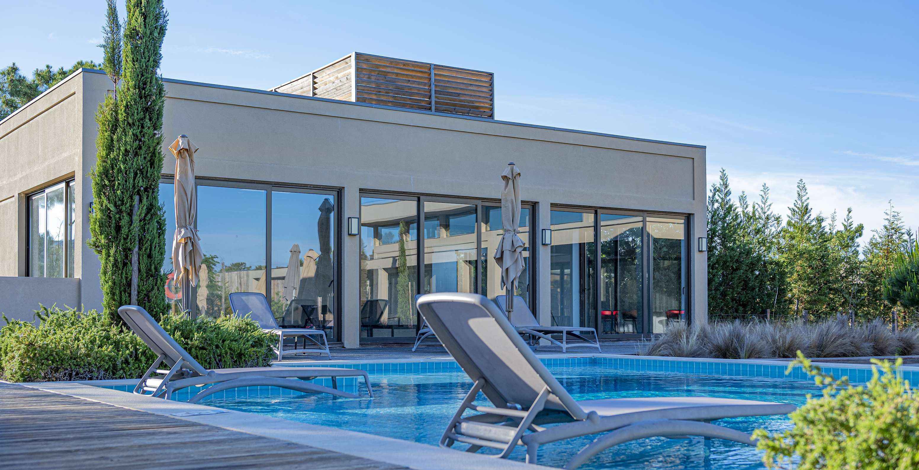 Außenpool im Pestana Tróia Eco Resort mit zwei Liegen im Wasser, wo man sich entspannen kann