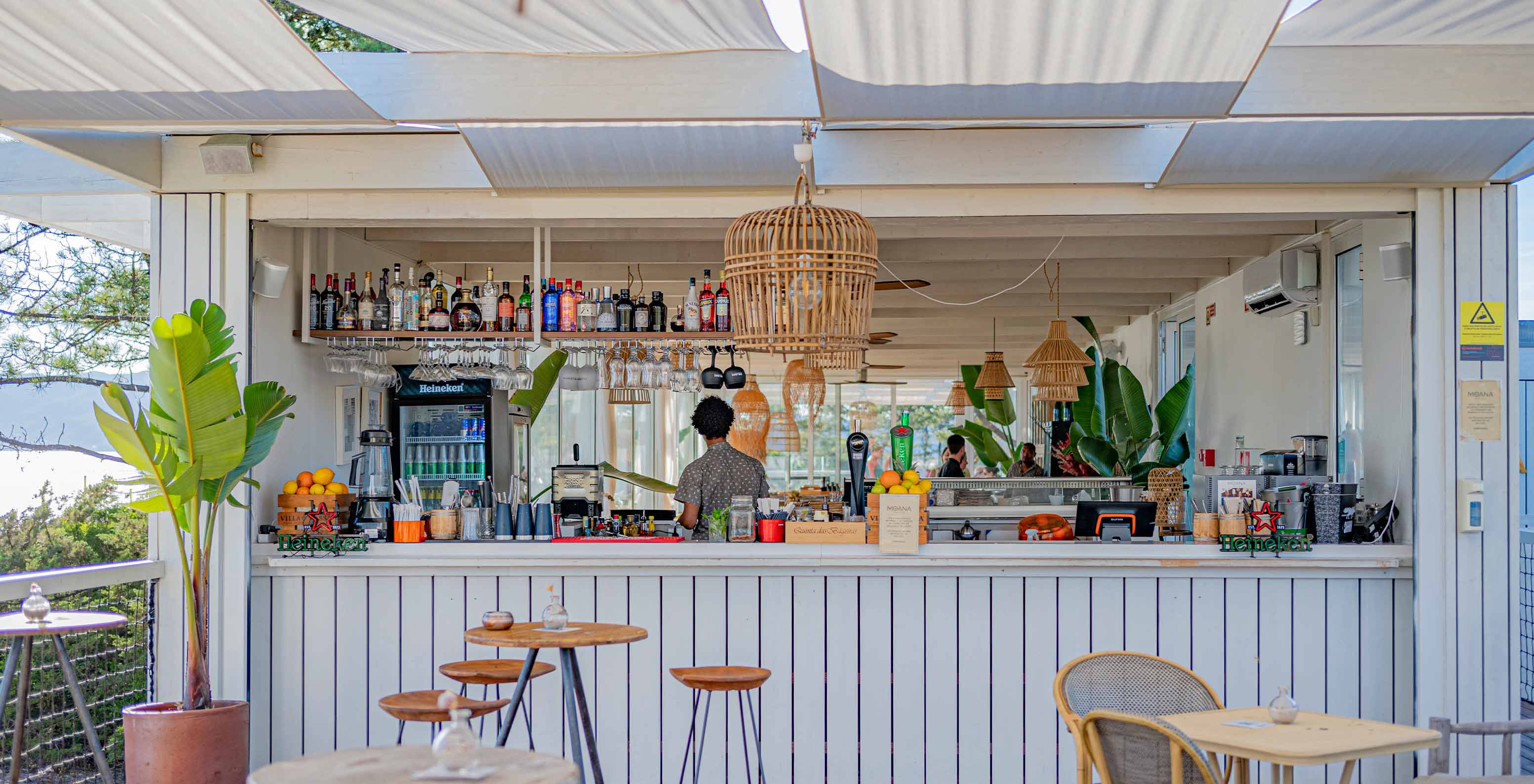 Die Moana Beach Club Bar im Pestana Tróia Eco Resort hat Holztische, Stühle und eine Getränketheke