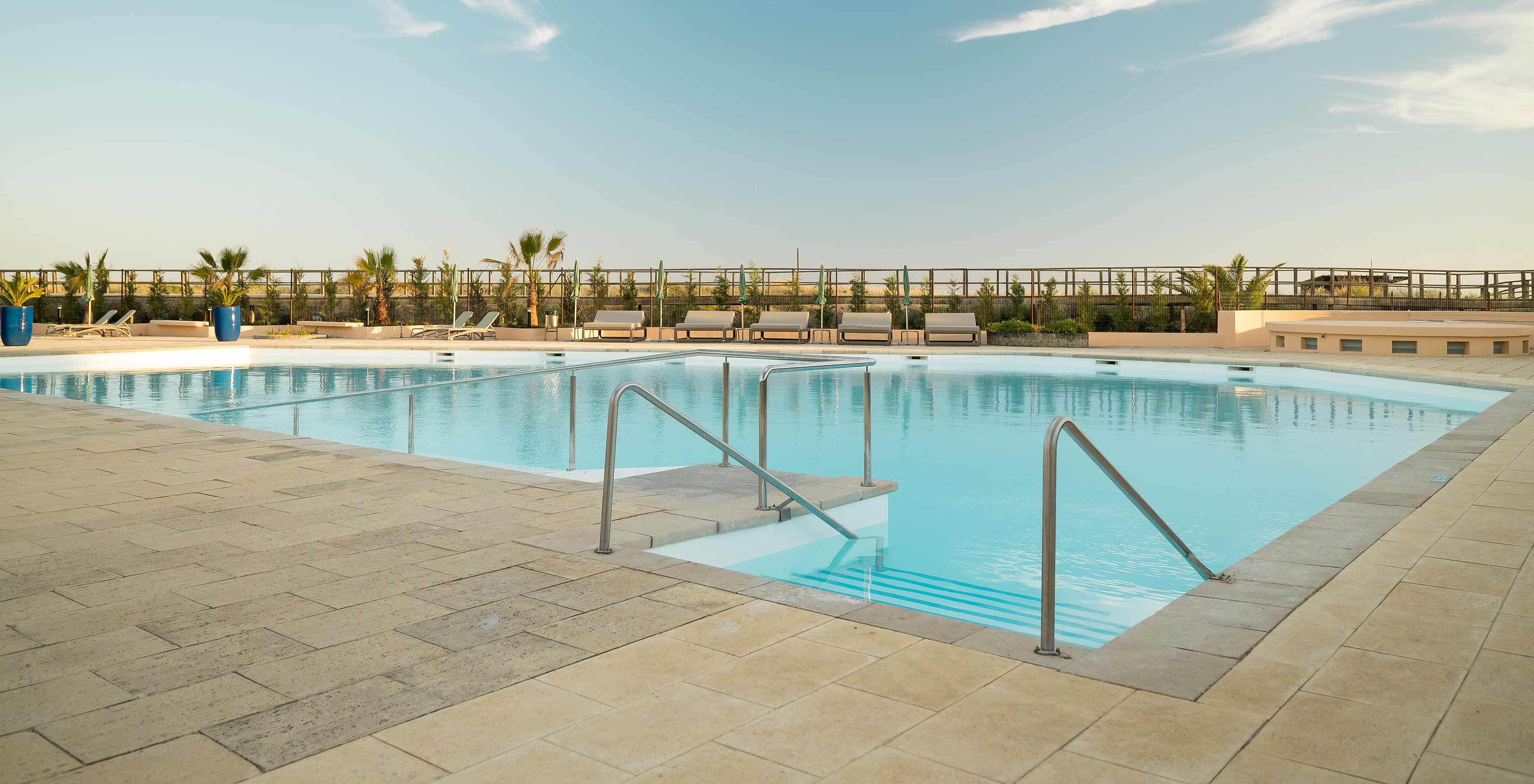 Außenpool im Pestana Alvor Beach Villas, komfortable Liegestühle, Palmen, viel Grün und entspannte Atmosphäre