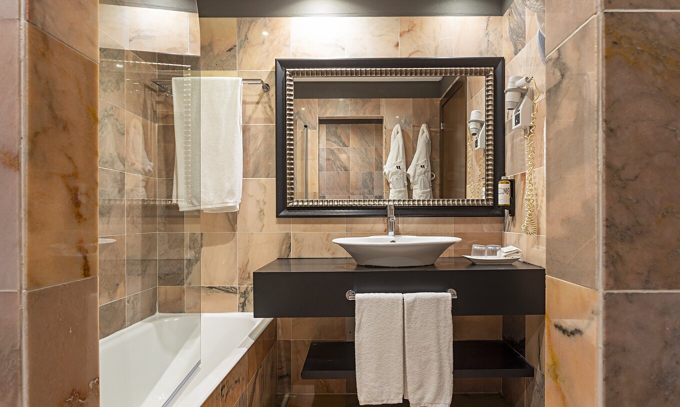 Das Cliff Studio im Pestana Alvor Praia hat ein Badezimmer mit einer Badewanne, zwei Bademänteln und einem Haartrockner