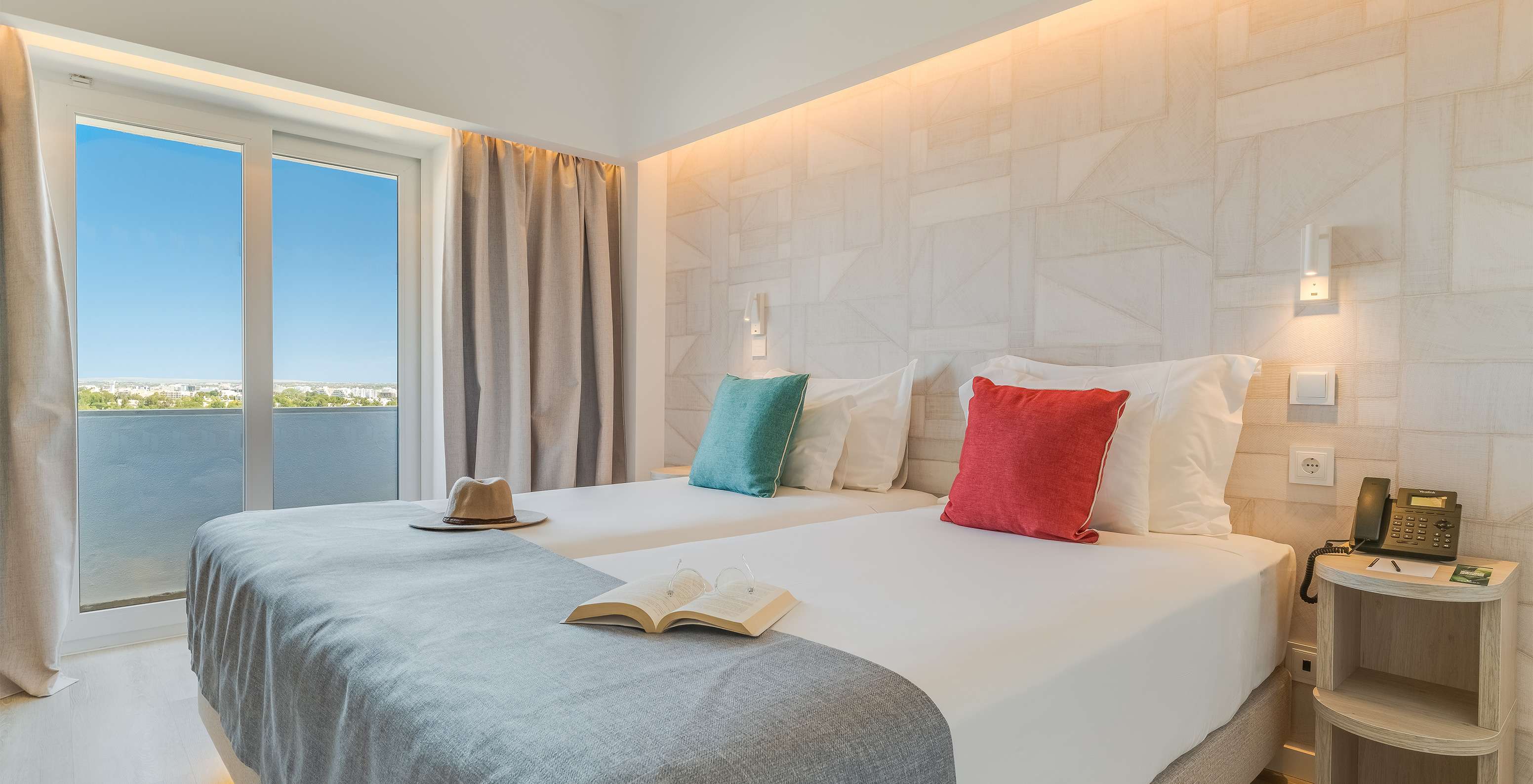 Das Klassische Zimmer mit Gartenblick im Pestana Blue Alvor Beach hat zwei Betten mit weißen Laken und bunten Kissen