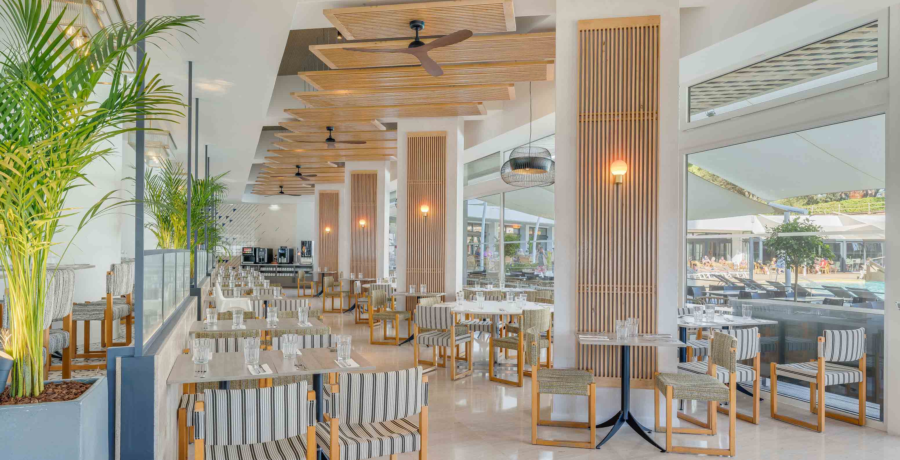 Die Acqua Bar im All-Inclusive-Hotel an der Algarve verfügt über Tische und Stühle mit viel Tageslicht.