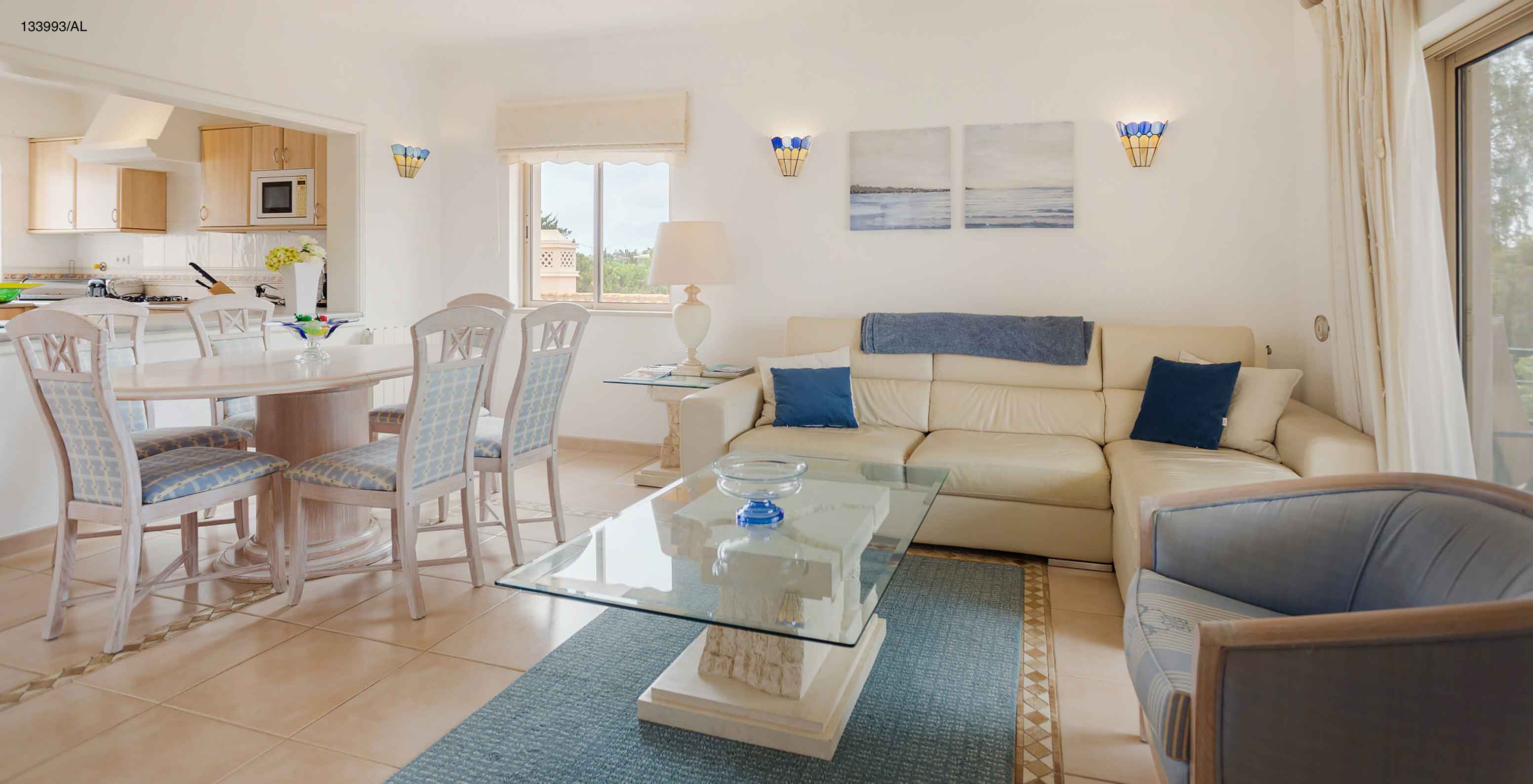 Die Wohnung Pestana Carvoeiro Golf T2 Superior hat ein Wohnzimmer mit weißem Sofa, Esstisch und sechs Stühlen
