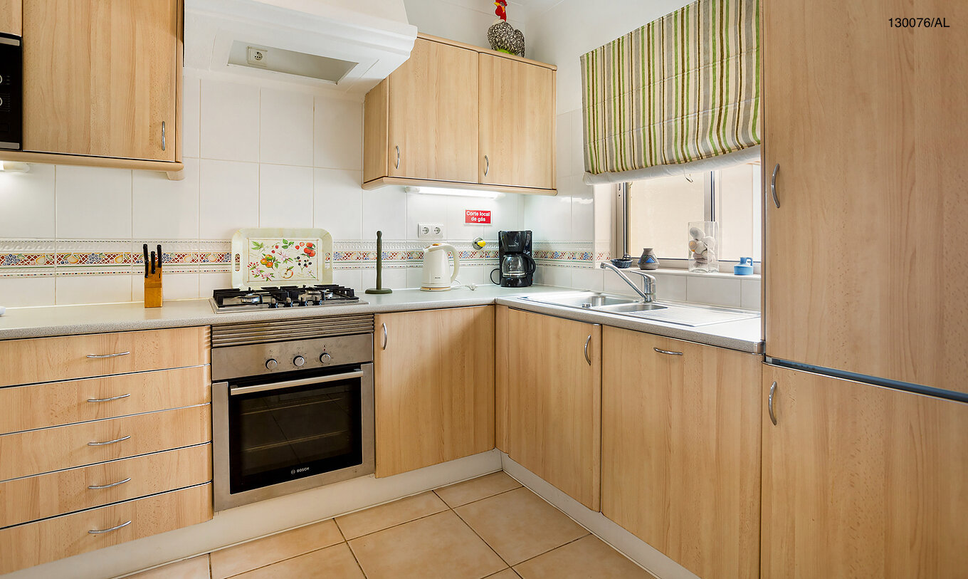Die Wohnung Pestana Carvoeiro Golf T2 Standard hat eine Küche mit Holzschränken und Geräten