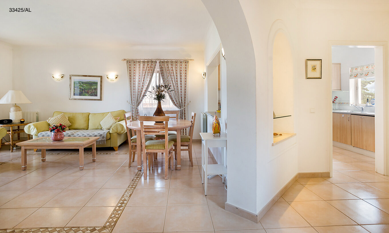 Die Wohnung Pestana Carvoeiro Golf T2 Standard hat ein Wohnzimmer mit grünen Sofas und einem Tisch mit Stühlen