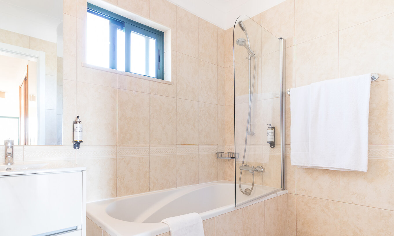 Das Studio im Pestana Gramacho Residences hat ein Bad mit Wanne, Dusche, Fenster und weißem Handtuch
