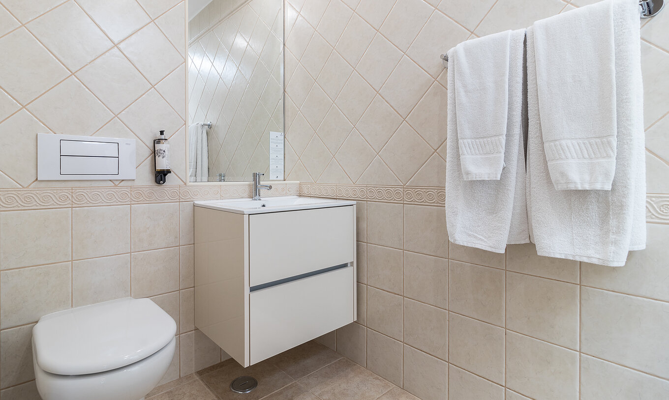 Das Zweizimmerapartment im Pestana Gramacho hat ein elegantes Bad mit weißen Handtüchern und sanftem Licht