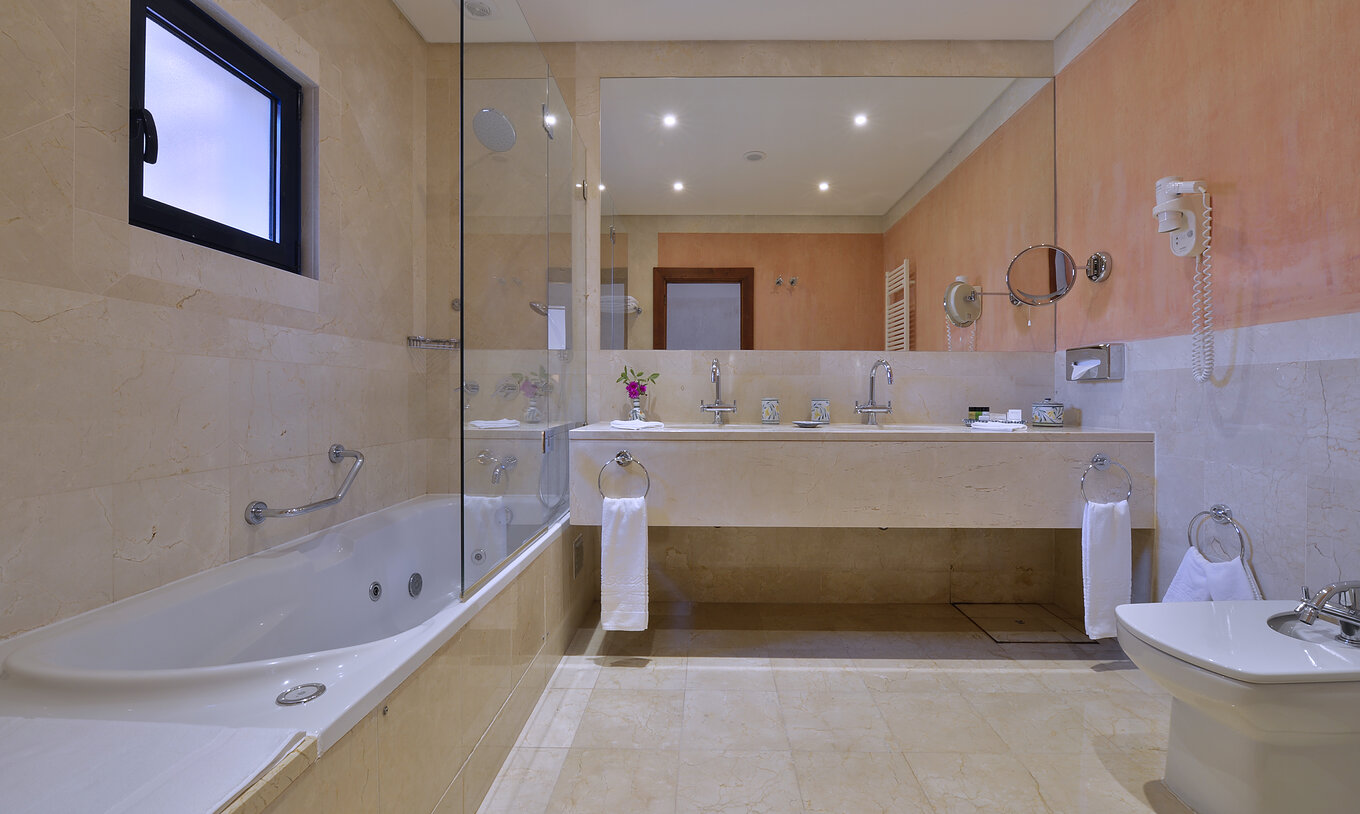 Suite Gardenblick Vila Sol Pestana Vila Sol - Vilamoura hat ein Badezimmer mit zwei Waschbecken und Badewanne mit Dusche