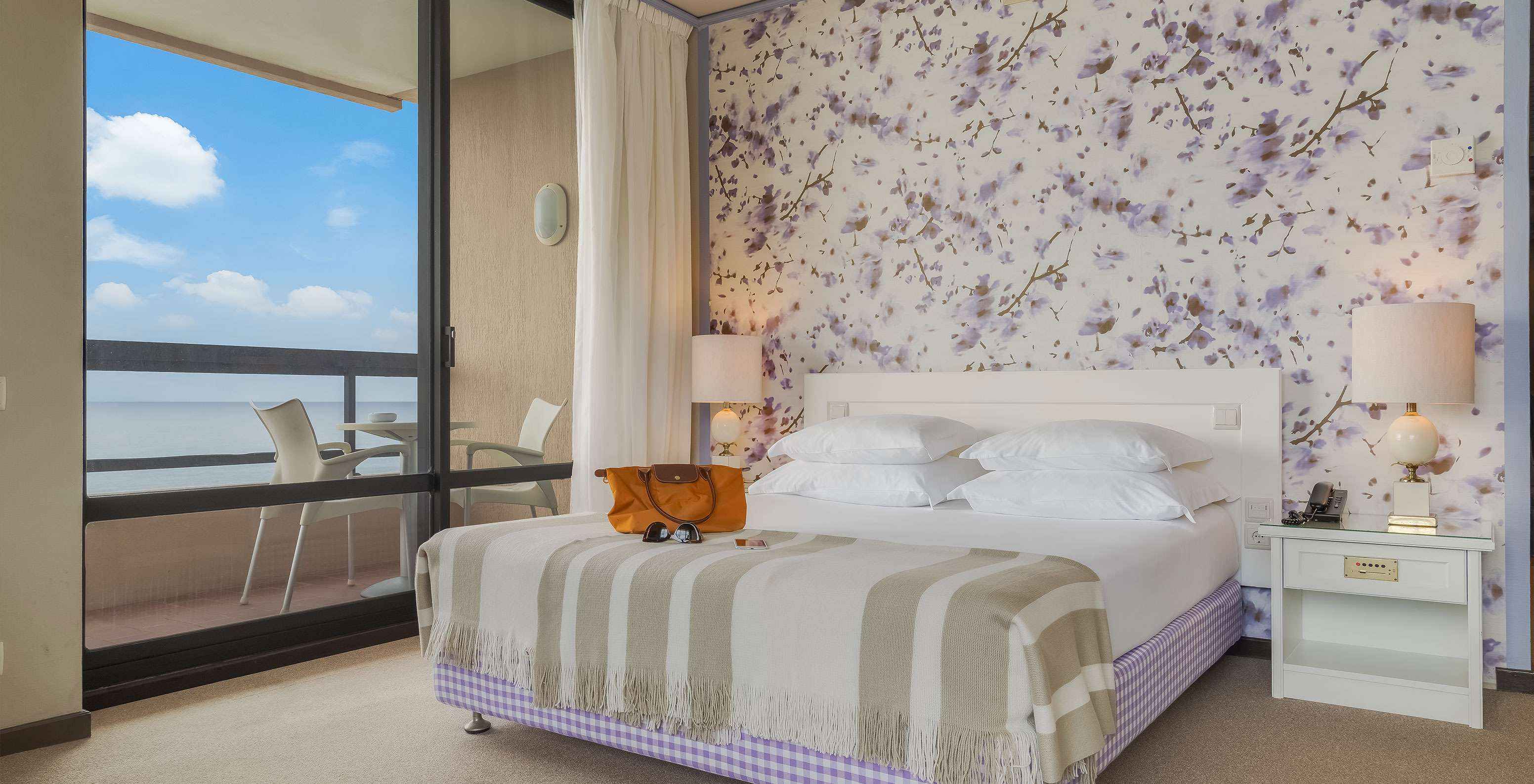 Das Standard Meerblick Zimmer im Pestana Bahia Praia hat ein Doppelbett mit vier Kissen und einen Balkon mit Meerblick