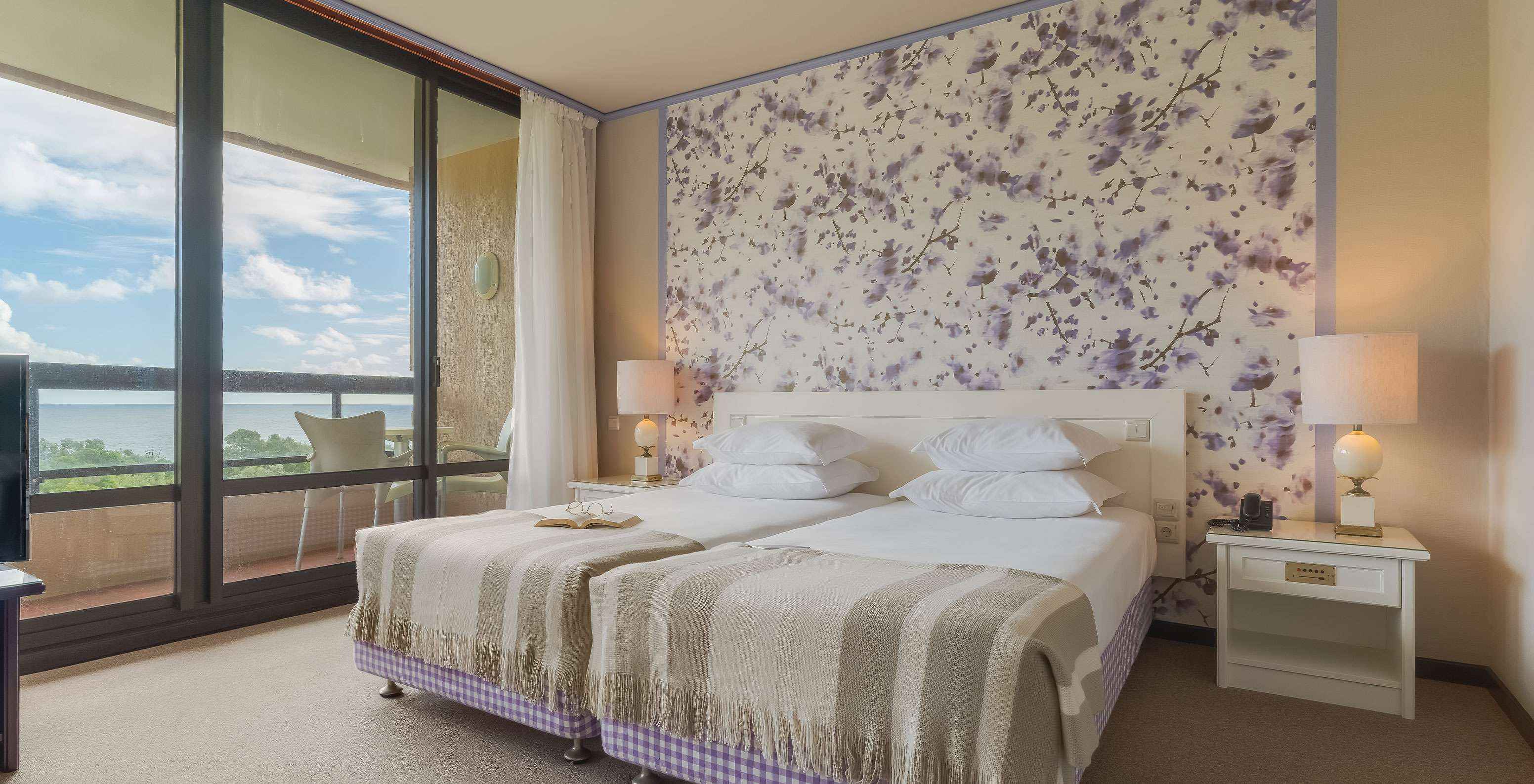 Die Junior Suite mit Gartenblick im Pestana Bahia Praia hat einen großen Raum mit zwei Einzelbetten, einem Sofa und Sessel