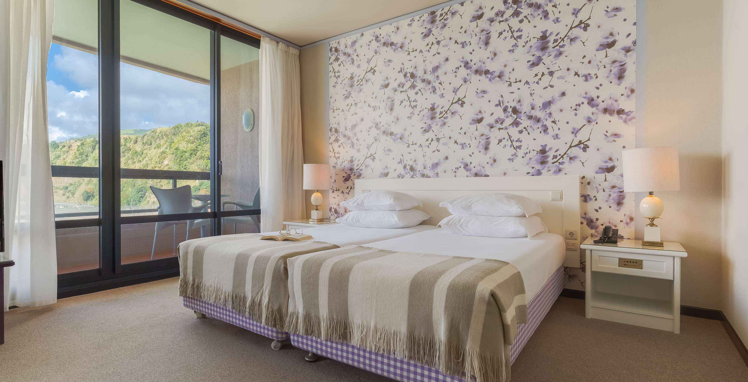 Die Junior Suite mit Meerblick im Pestana Bahia Praia hat einen großen Raum mit zwei Einzelbetten, einem Sofa und Sessel