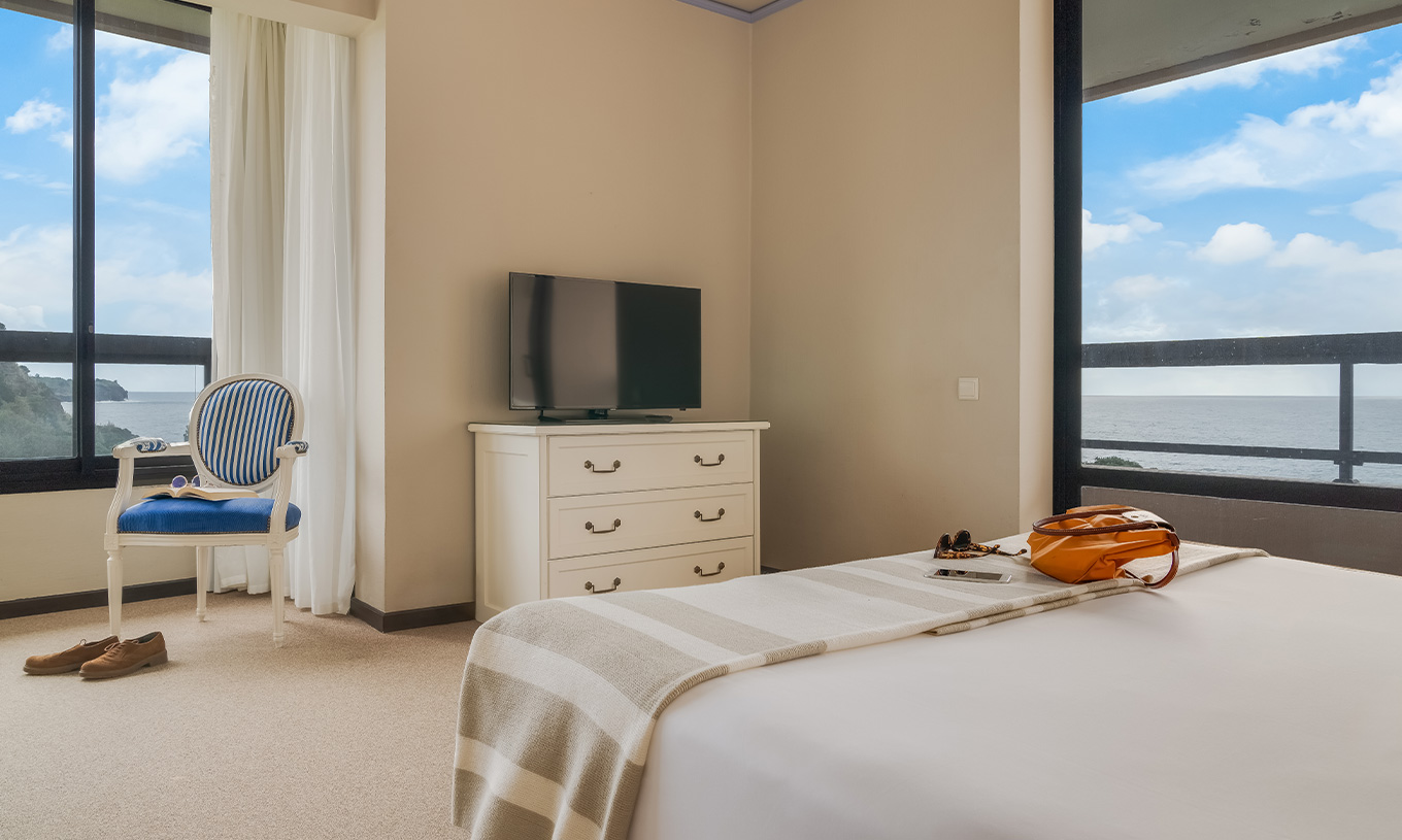 Das Standard Meerblick Zimmer im Pestana Bahia Praia hat zwei Fenster mit Meerblick und grüner Landschaft