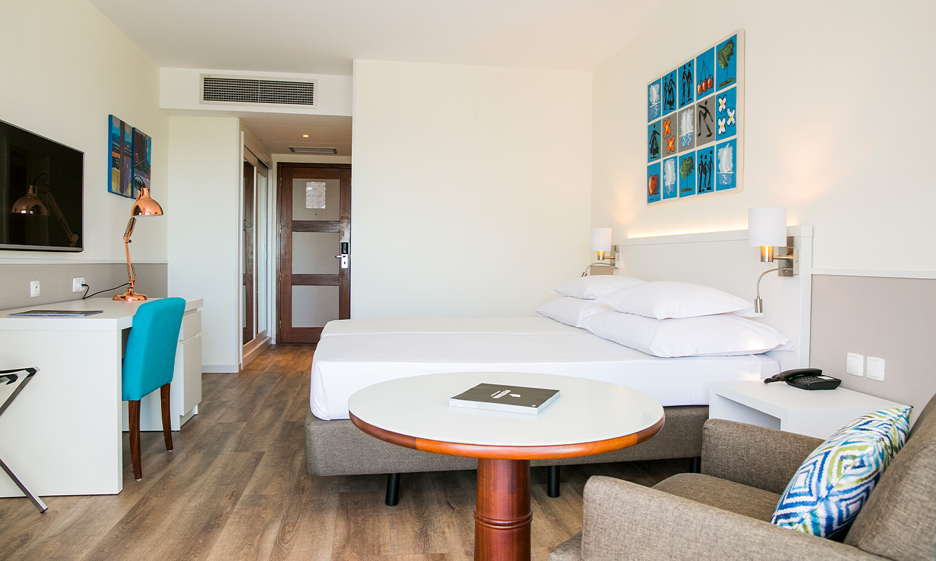 Das Deluxe Superior-Zimmer im Pestana Cascais hat zwei Einzelbetten, TV, Schreibtisch und Küche