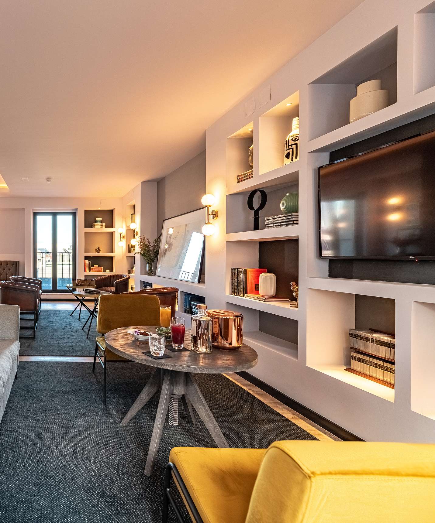 Lounge mit Sofas, Stühlen, Tischen, Bildern, Fernseher, Teppichen und Dekorationsgegenständen mit Stadtblick