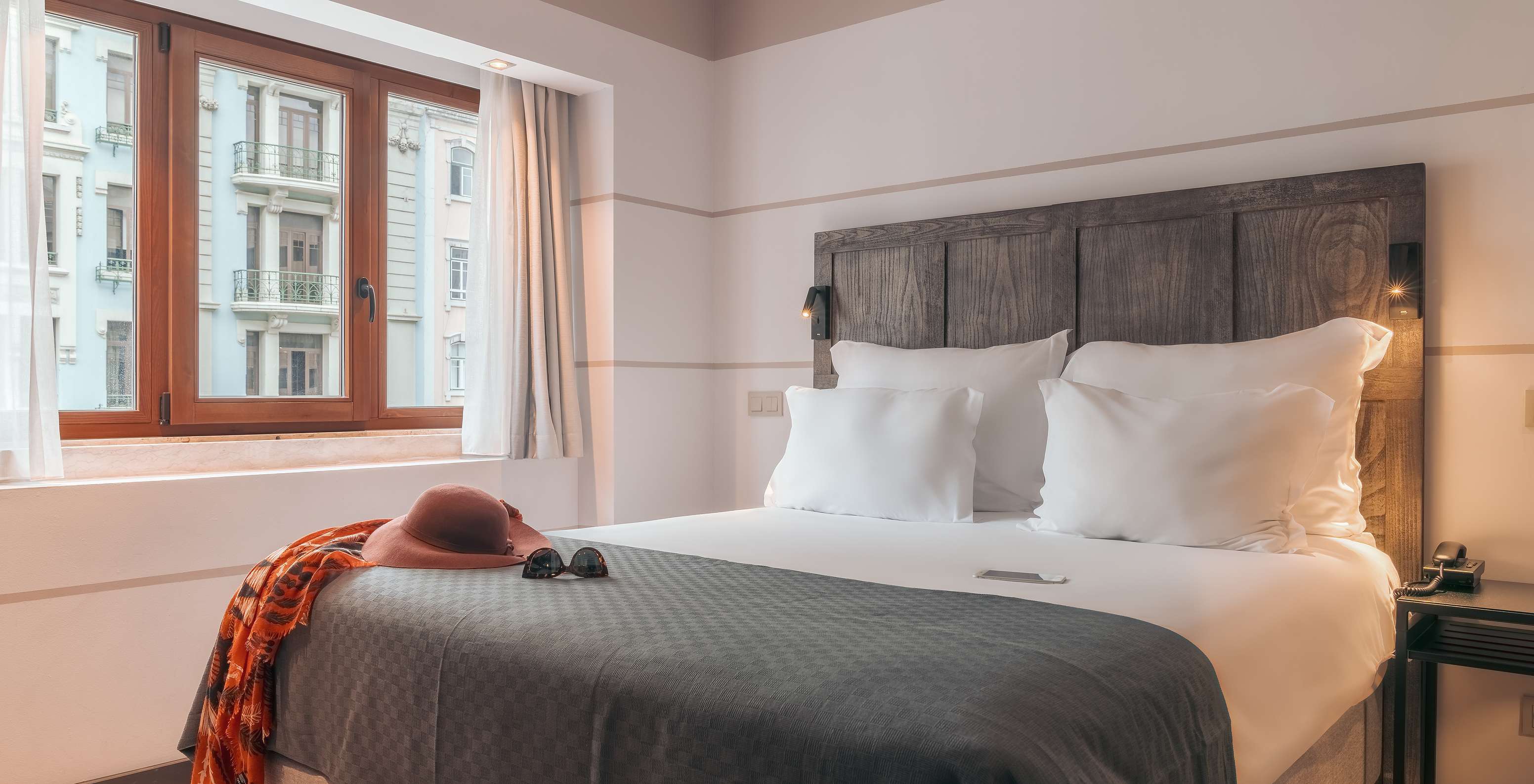 Das Double Classic im Pestana Lisboa Vintage hat Doppelbett mit Kopfteil, grauer Decke und Holzfenster