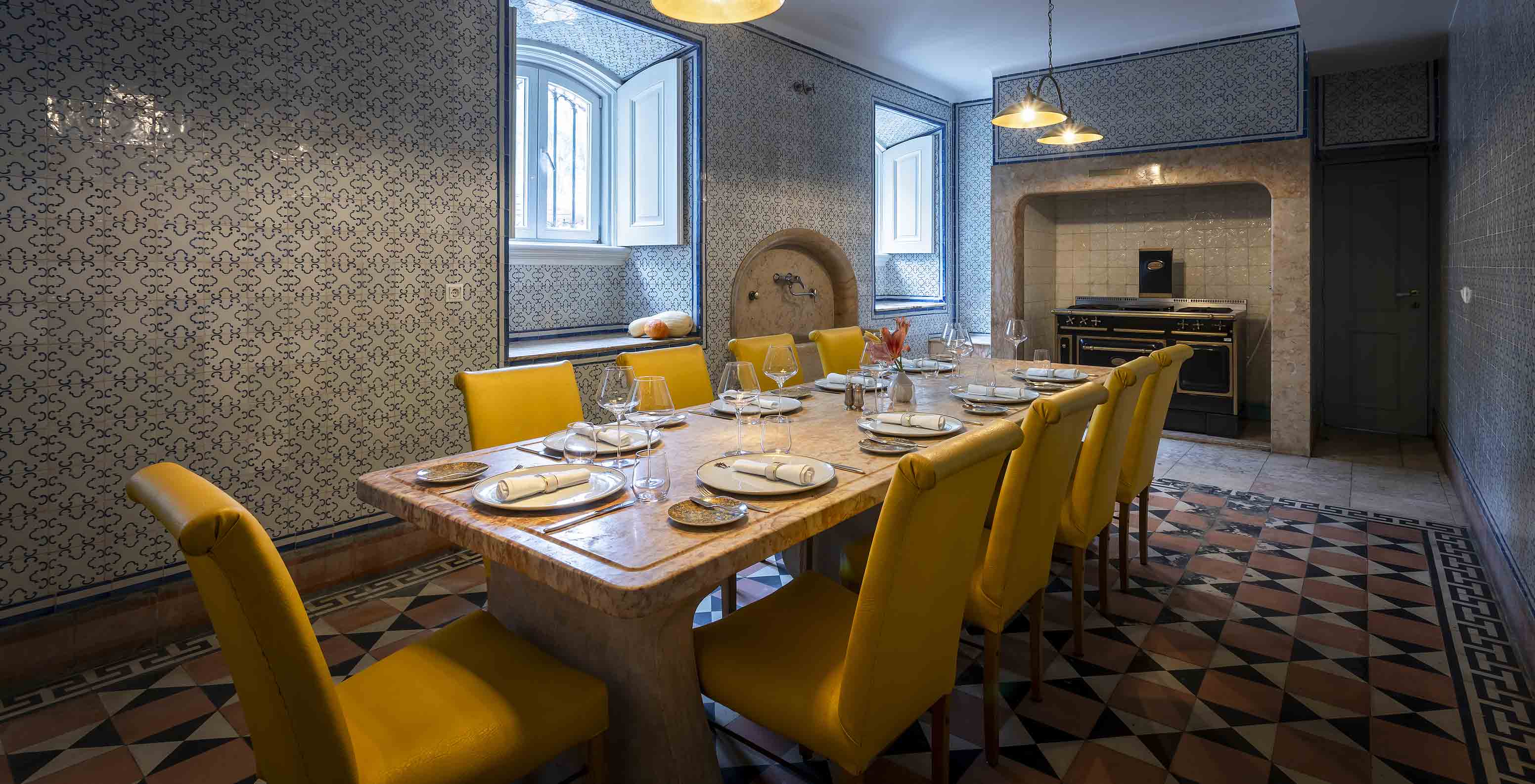 Das Pestana Palace Lisboa hat eine alte Küche für private Veranstaltungen mit einem Steintisch und gelben Stühlen