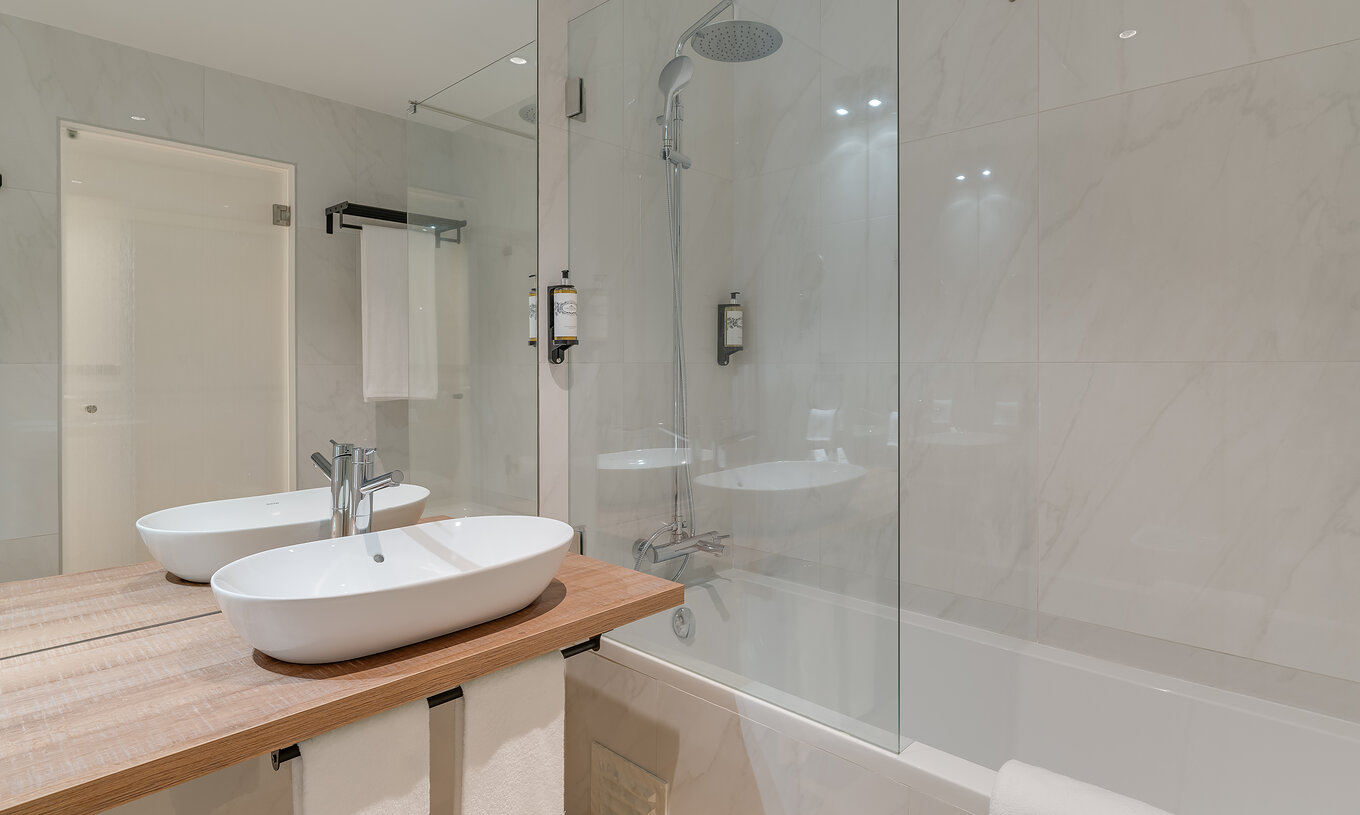 Das Familienzimmer im Clubhaus Pestana Sintra Golf hat ein modernes Bad mit Badewanne und Spiegel