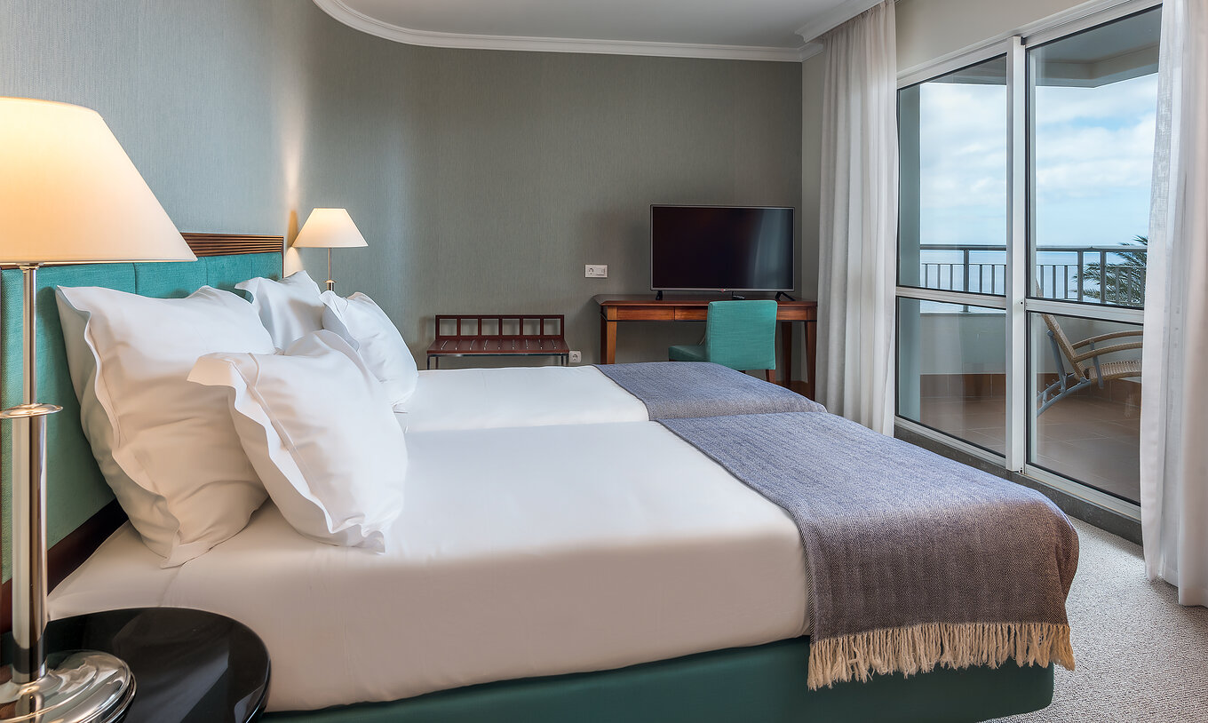 Die Standard Suite mit Meerblick im Pestana Grand hat zwei Einzelbetten, Fernseher und Schreibtisch