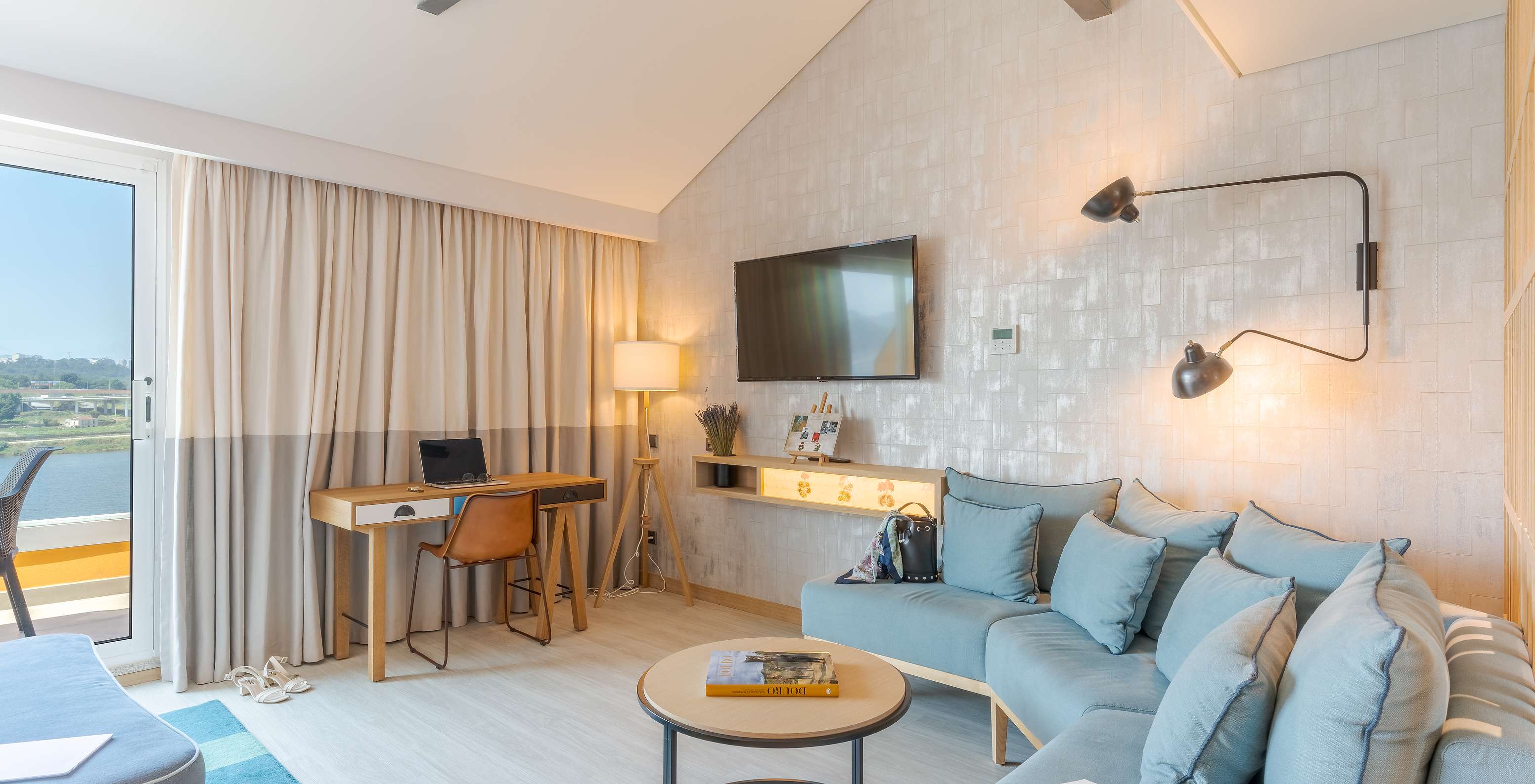 Die Junior Suite im Pestana Douro Riverside hat einen Fernseher, Schreibtisch und ein Sofa