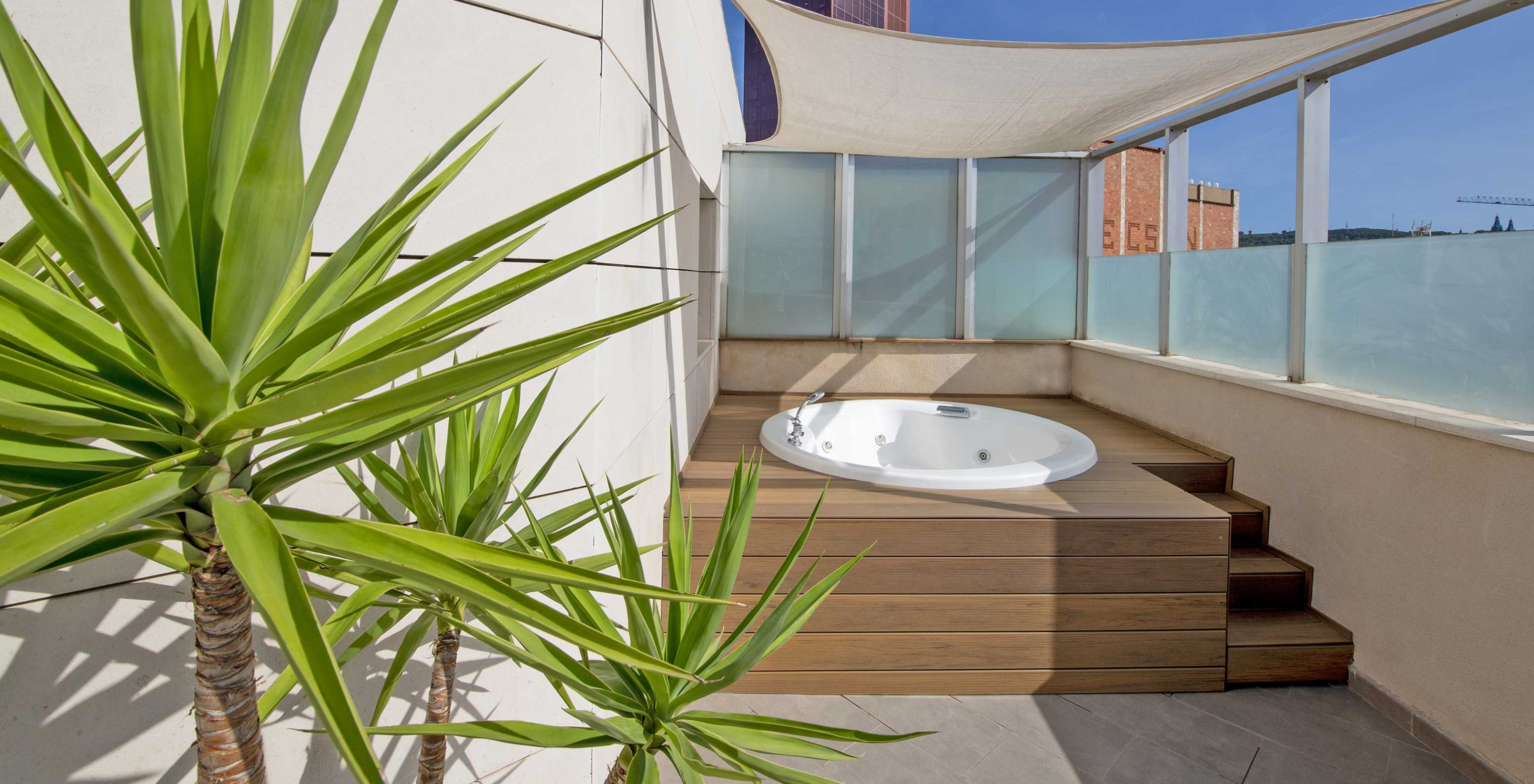 Die Junior Suite mit Jacuzzi auf der Terrasse im Pestana Arena Barcelona bietet Terrasse mit Jacuzzi, Stühlen und Pflanzen