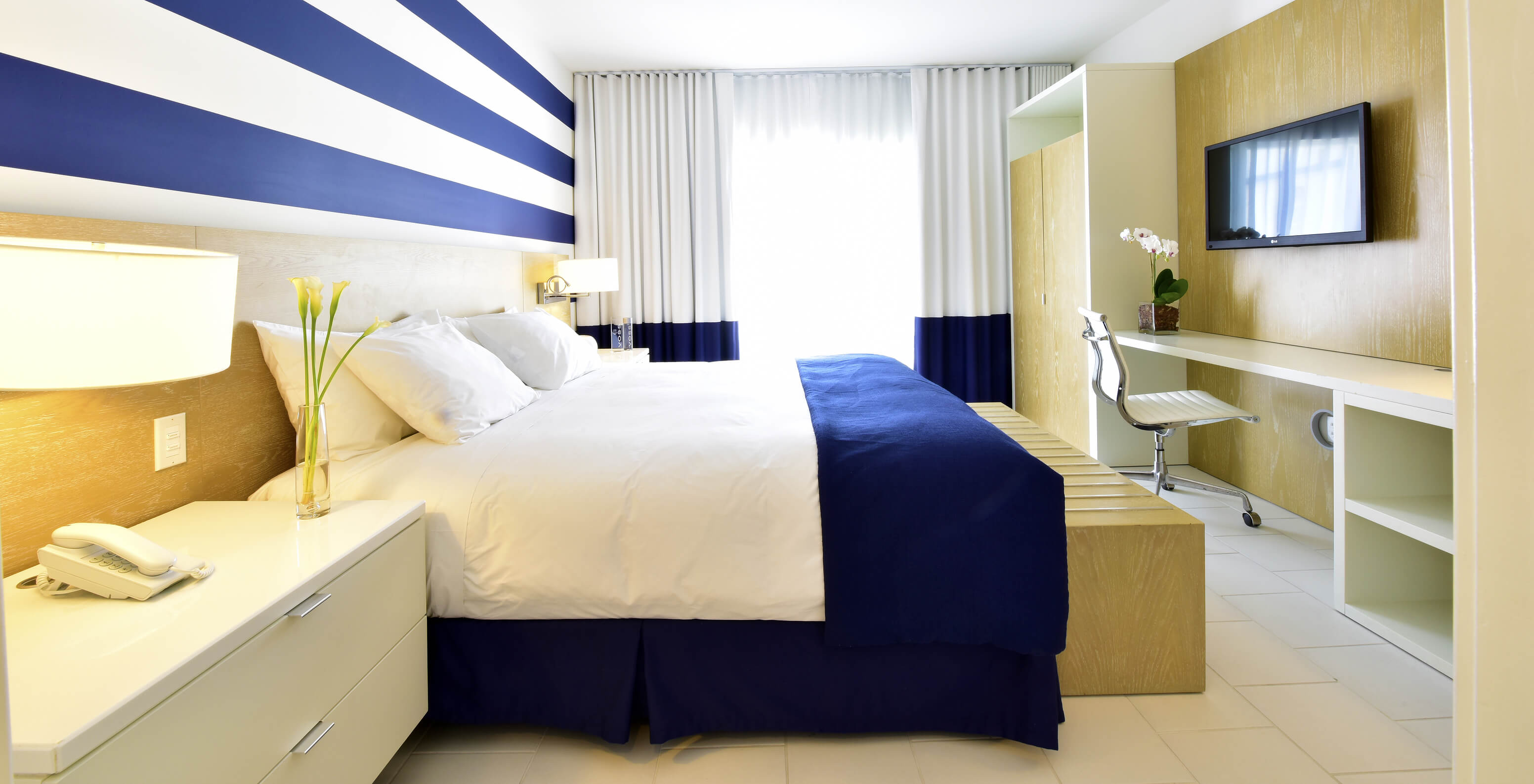 Die Suite King mit Balkon im Pestana Miami ist modern mit großem Bett und blau-weißer Deko.