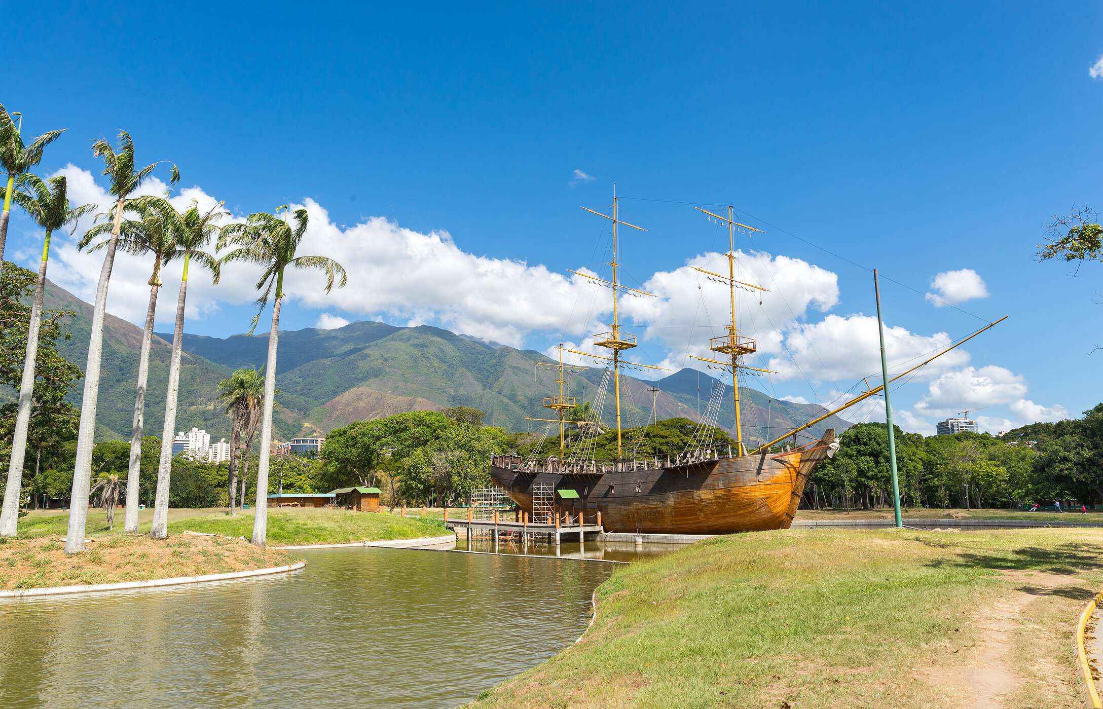 Parque del Este, gelegen in Caracas, mit einem See und einem verankerten historischen Schiff, mit Bergen und Vegetation im Hintergrund