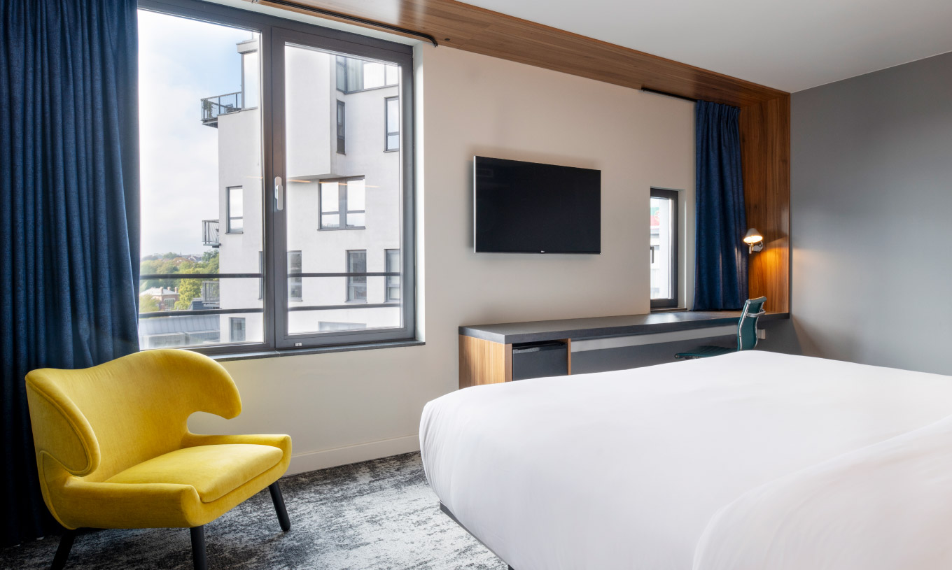 The Standard King at Pestana Brussels Schuman has a double bed, two windows, and a wall-mounted television