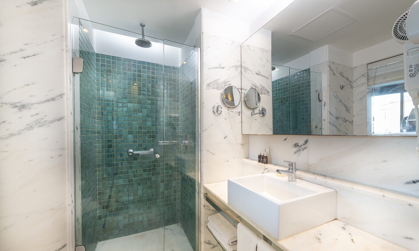 The Queen Side Sea View of Pestana Rio Atlântica has a bathroom with shower, sink with mirror, and magnifying mirror