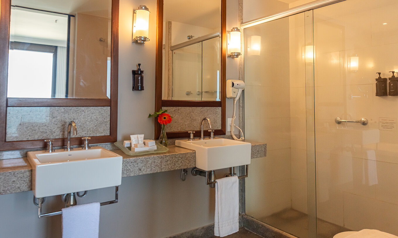 The Suite Beach Front at Pestana Rio Atlântica has a bathroom with double sinks and a large shower.