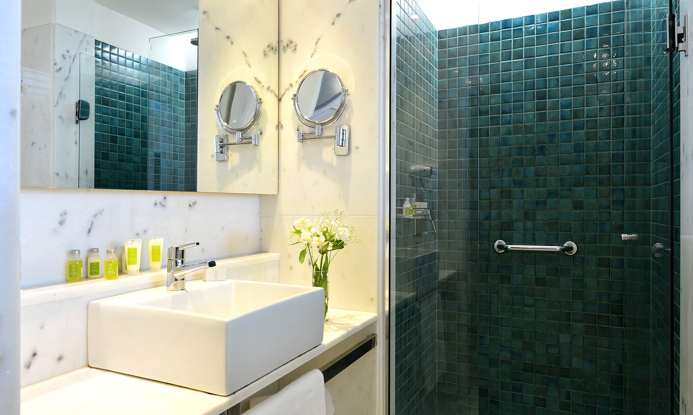 The Twin Standard of Pestana Rio Atlântica has a bathroom with shower, sink with mirror, and amenities
