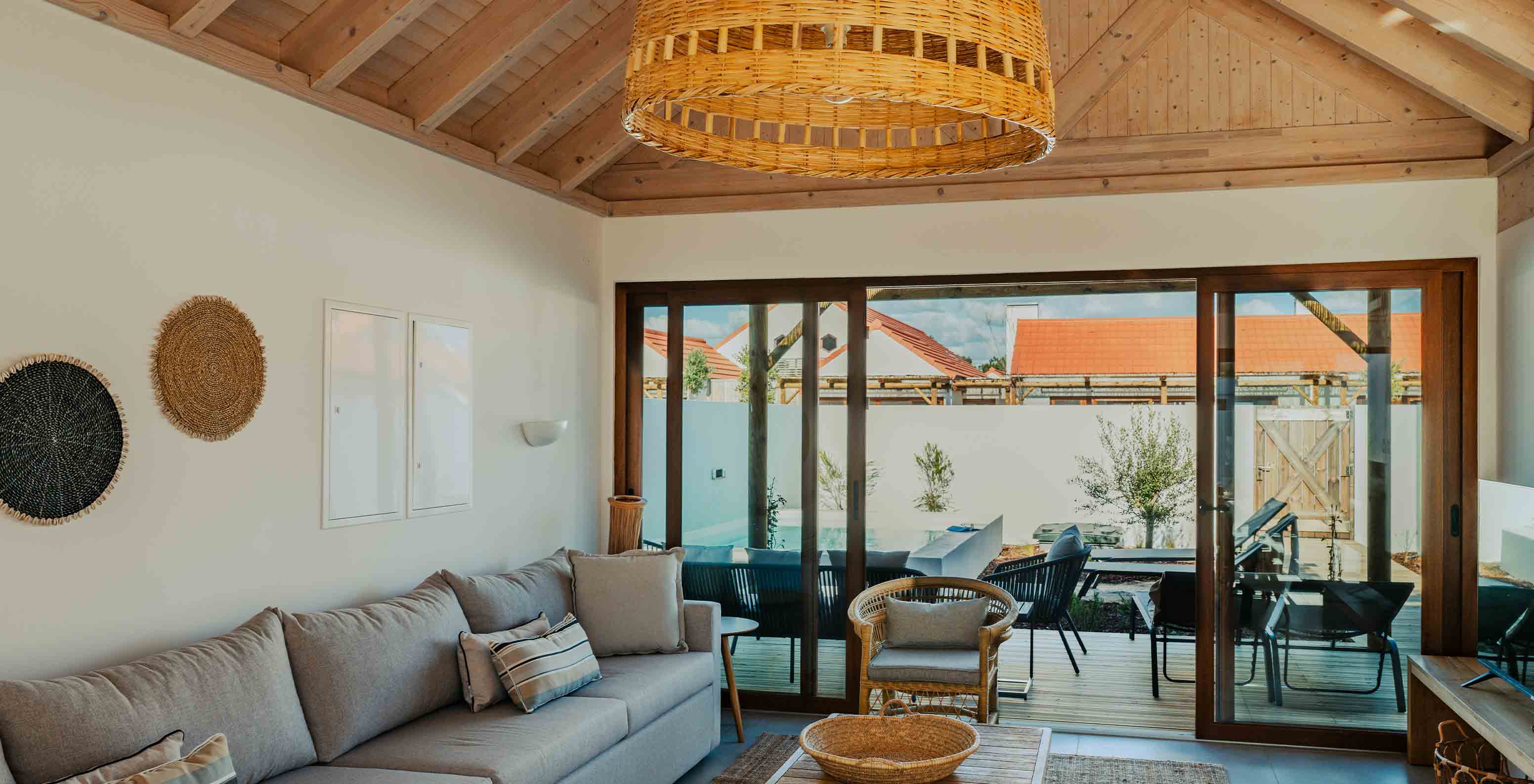 The Superior Villa at Pestana Comporta Village Residences has a living room with a gray sofa and a balcony in the background