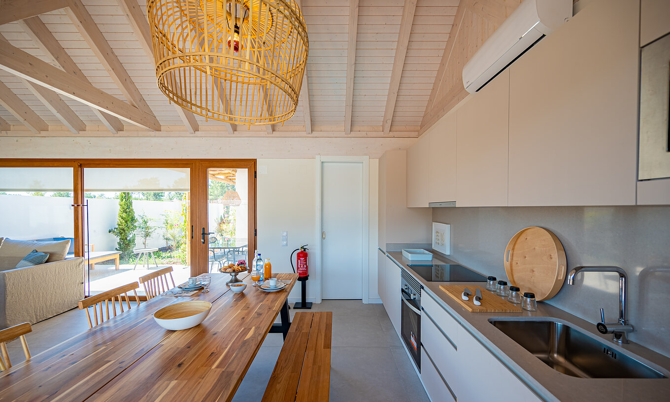 The Standard Green Villa at Pestana Comporta Village Residences has a modern kitchen with a wooden table and an oven