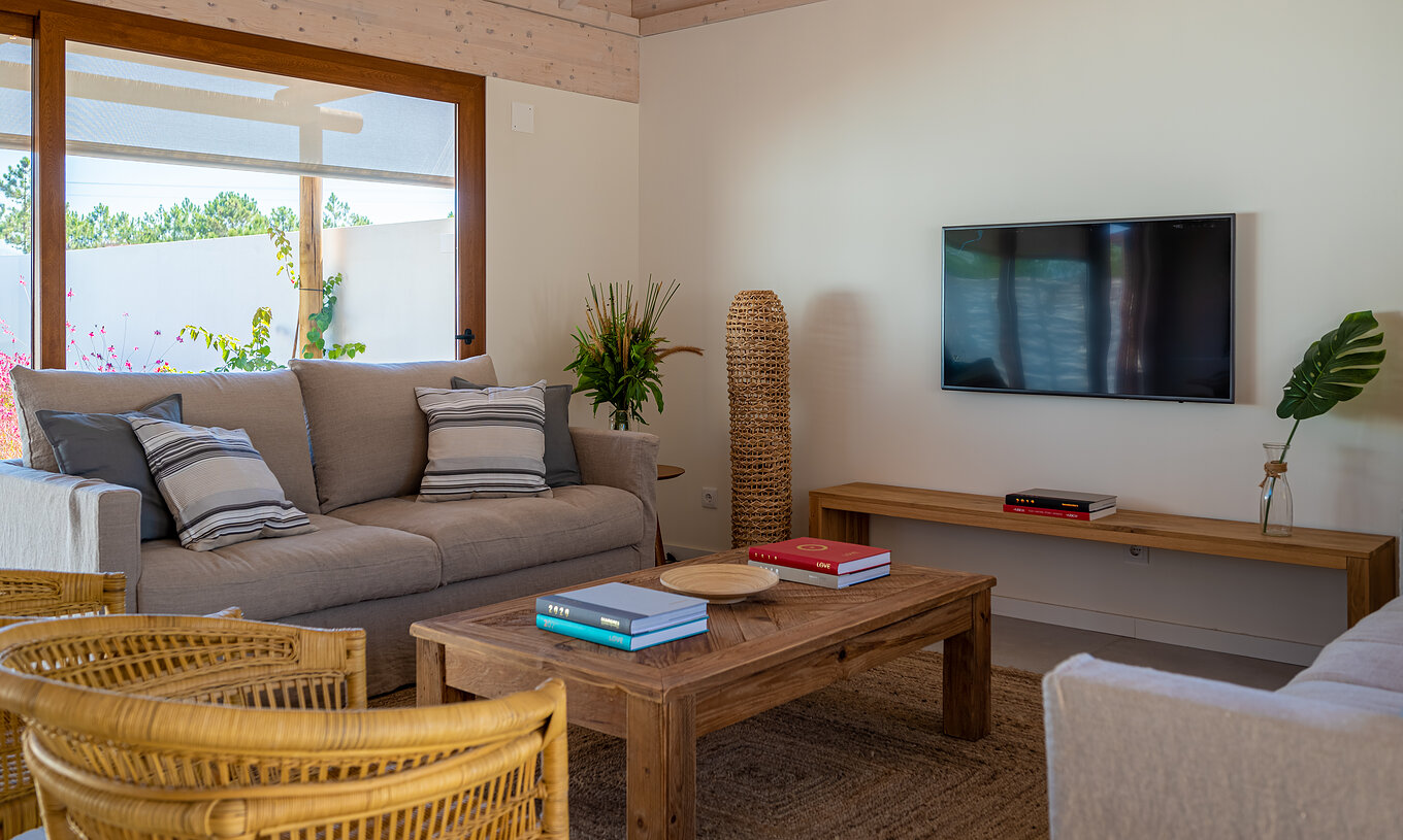 The Standard Villa T2 at Pestana Comporta Village Residences has a living room with a sofa and a TV on the wall
