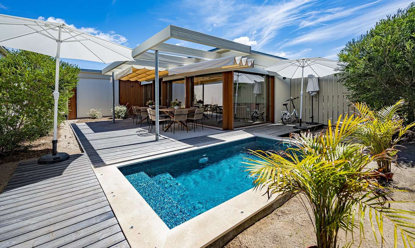 The Aqua Villa of Pestana Tróia Eco Resort has a private pool with a table and chairs beside