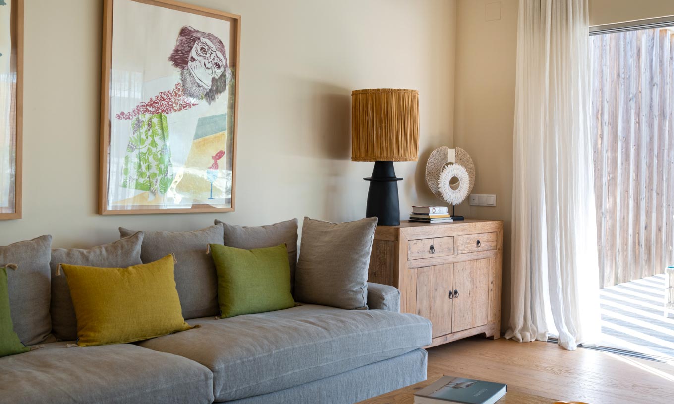 The exclusive villa with a pool at Pestana Tróia Eco Resort has a living room with a gray sofa and large window with curtains