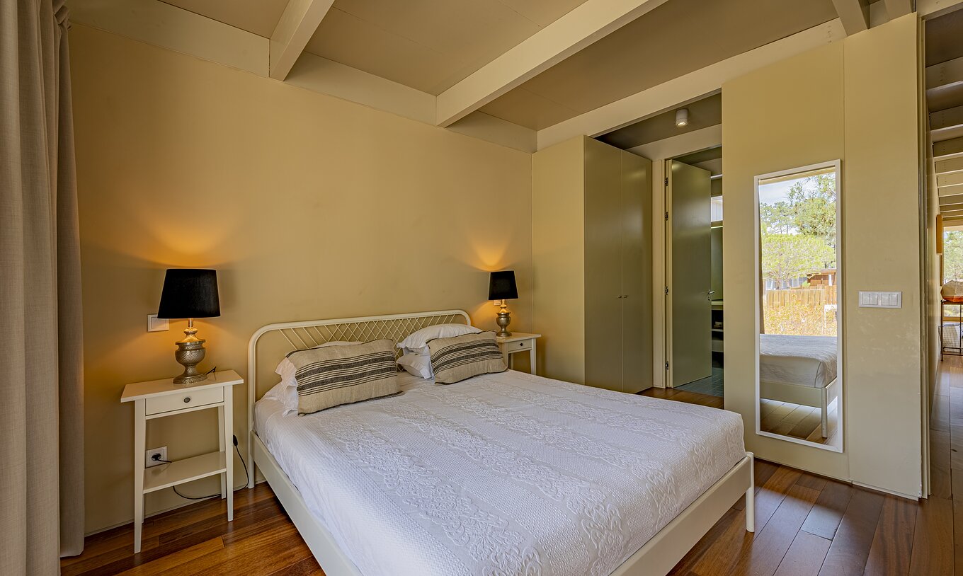 The Townhouse of Pestana Tróia Eco Resort has a double bed, two bedside tables, and a mirror on the wall