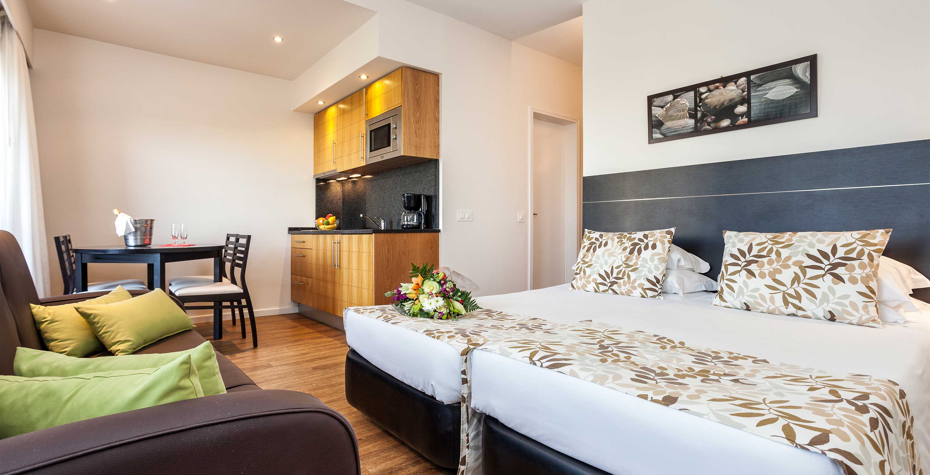 The Garden View Studio at Pestana Alvor Atlântico is an apartment with a bed, sofa, table, and kitchenette